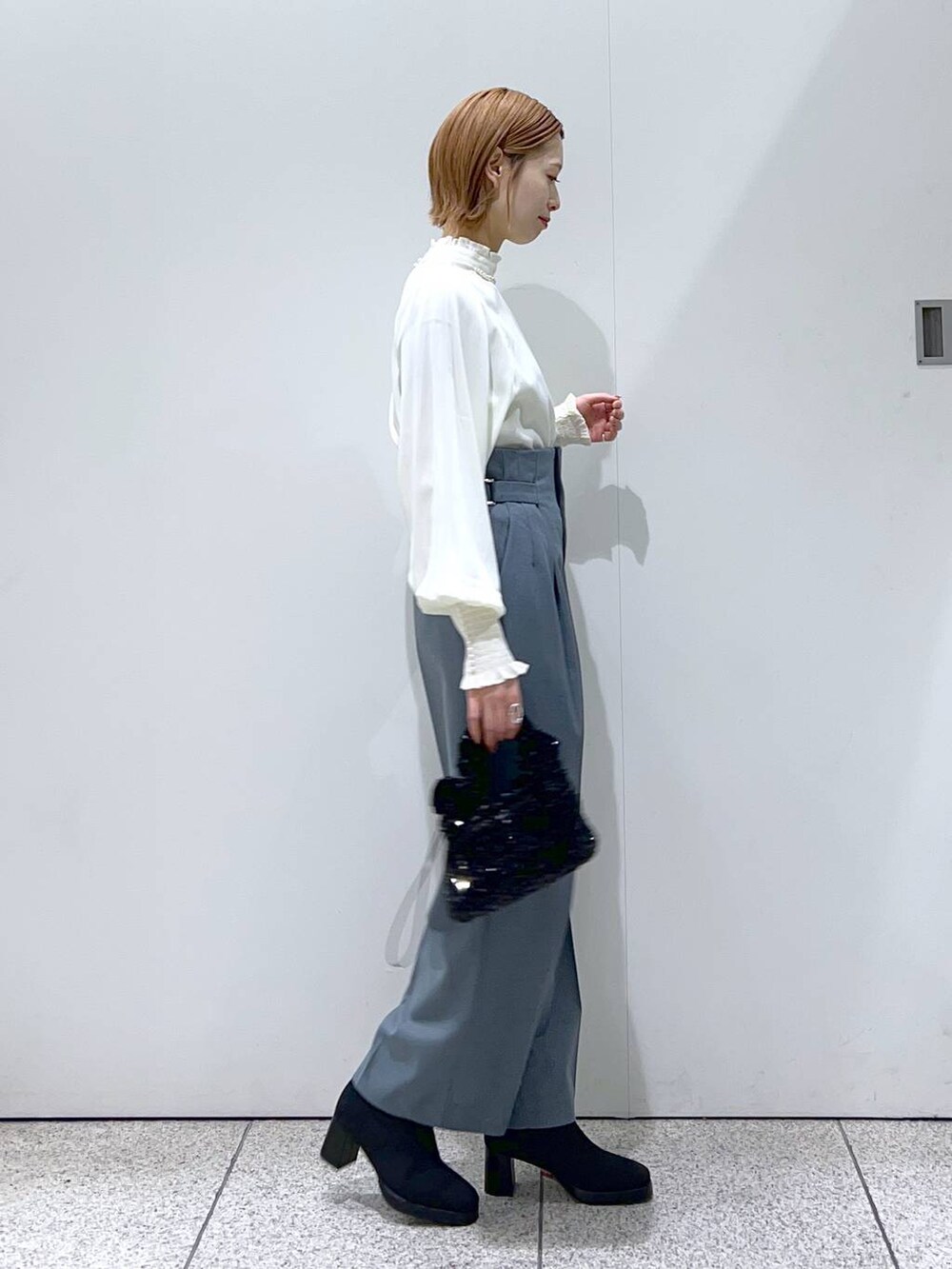 ブルー系のその他パンツ、ブラック系のブーツ、ブラック系のハンドバッグを着用したレディースの冬コーディネートの2枚目の写真