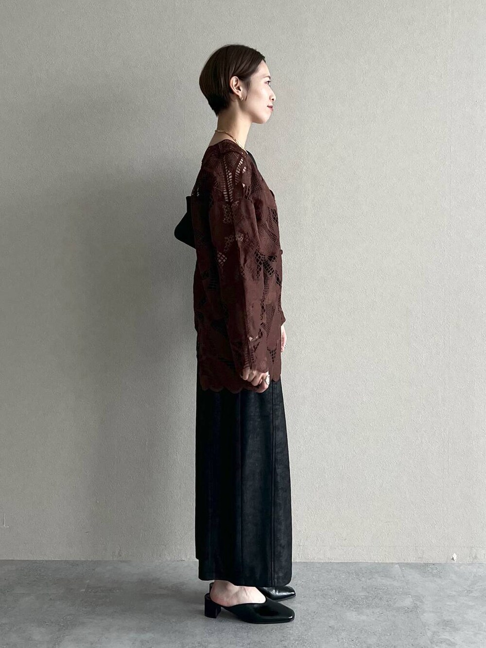 ブラウン系のシャツ/ブラウス、ブラック系のスカート、ブラック系のスリッポンを着用したレディースの秋コーディネートの2枚目の写真