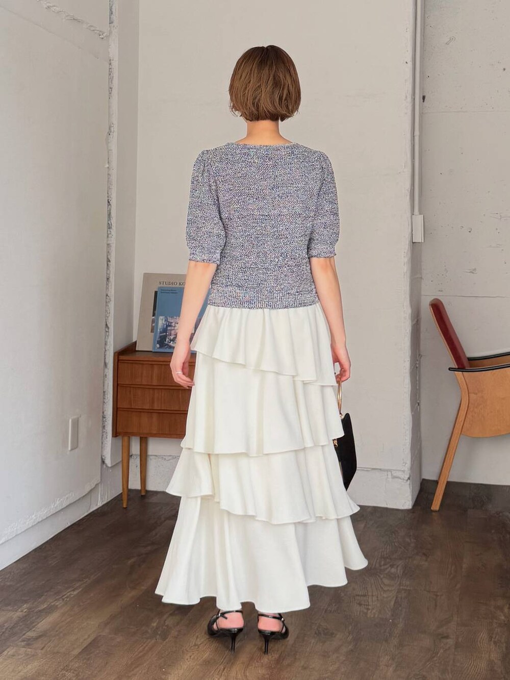 ホワイト系のスカート、ブラック系のサンダル、ブラック系のショルダーバッグを着用したレディースの春コーディネートの3枚目の写真