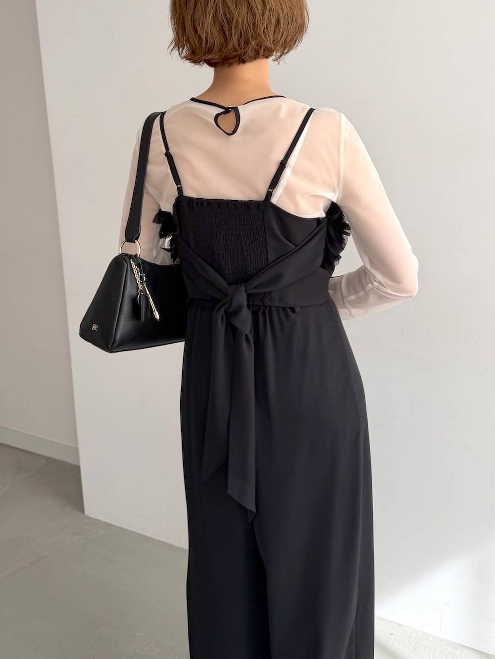 ブラック系のサンダル、ブラック系のショルダーバッグ、ブラック系のパンツドレスを着用したレディースの春コーディネートの5枚目の写真