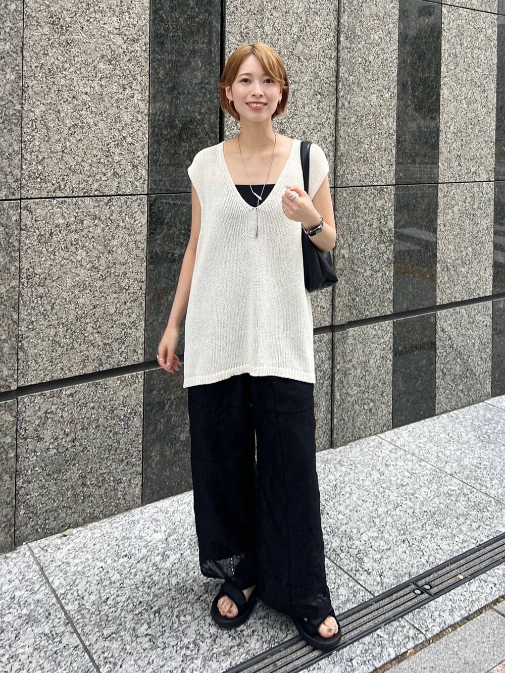 ホワイト系のニット/セーター、ブラック系のキャミソール、ブラック系のその他パンツを着用したレディースの夏コーディネートの3枚目の写真