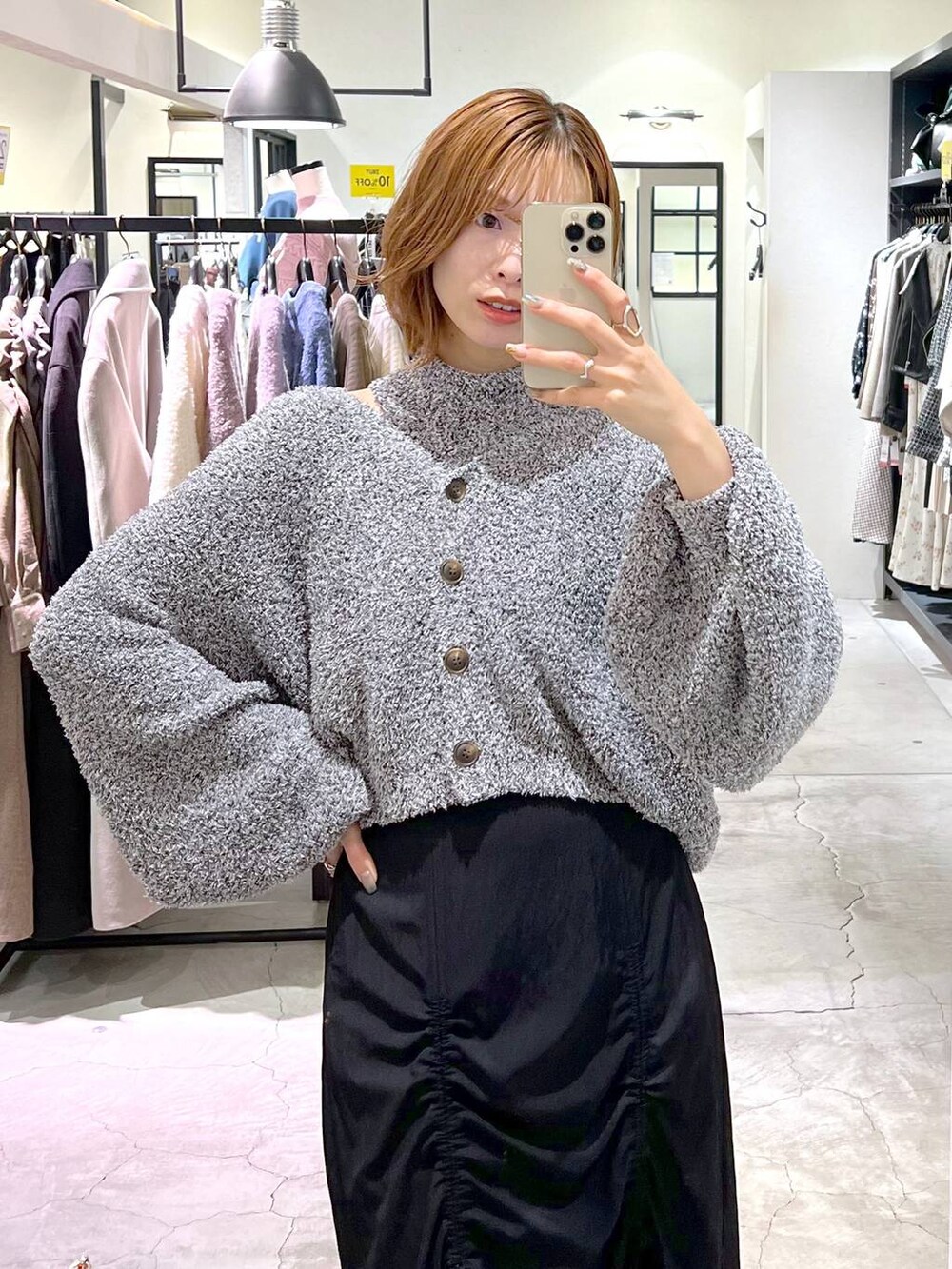 ブラック系のブーツ、オレンジ系のショルダーバッグ、ブラック系のスカートを着用したレディースの秋コーディネートの4枚目の写真