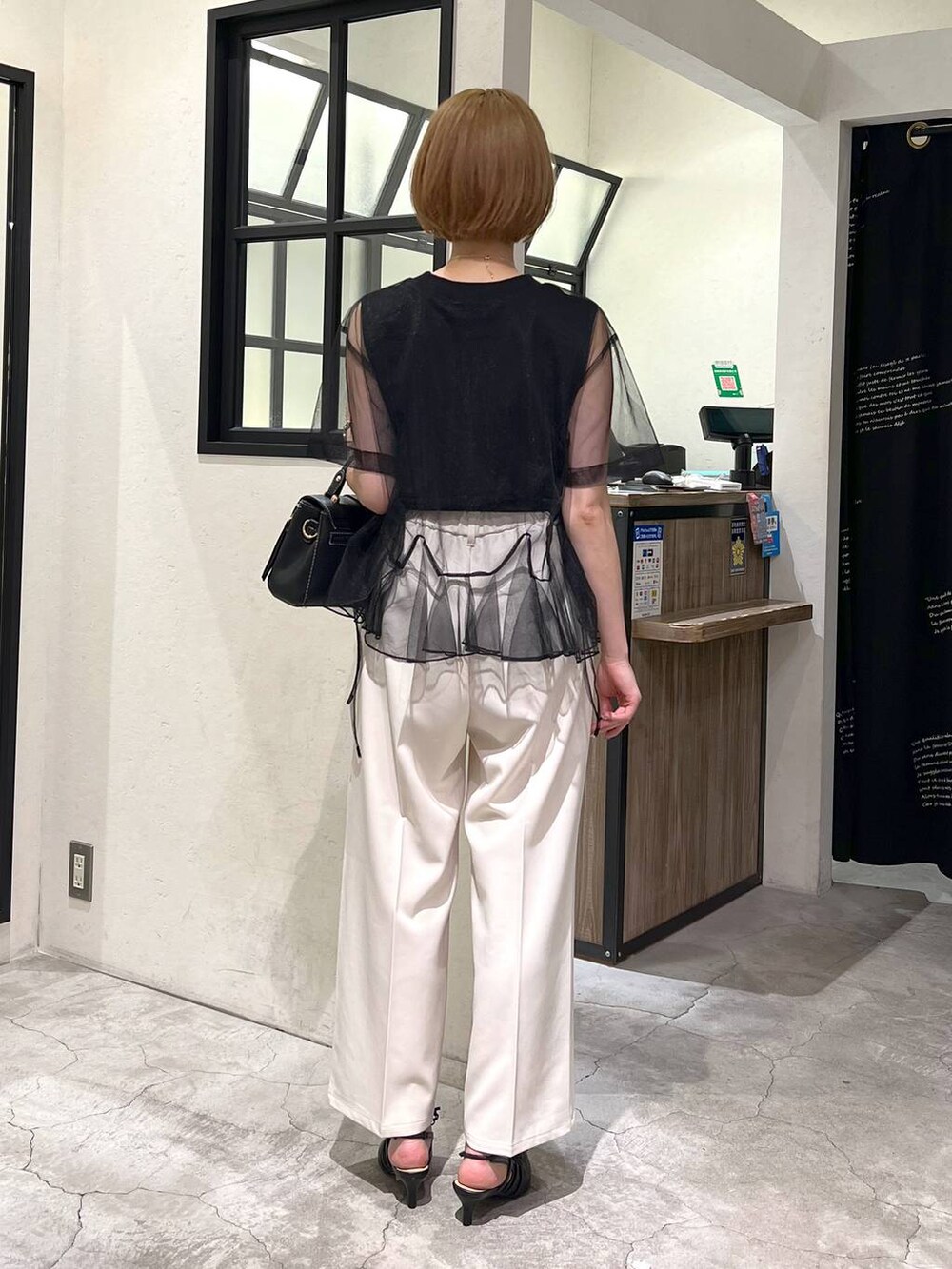 ブラック系のパンプス、ブラック系のショルダーバッグ、ブラック系のTシャツ/カットソーを着用したレディースの夏コーディネートの4枚目の写真