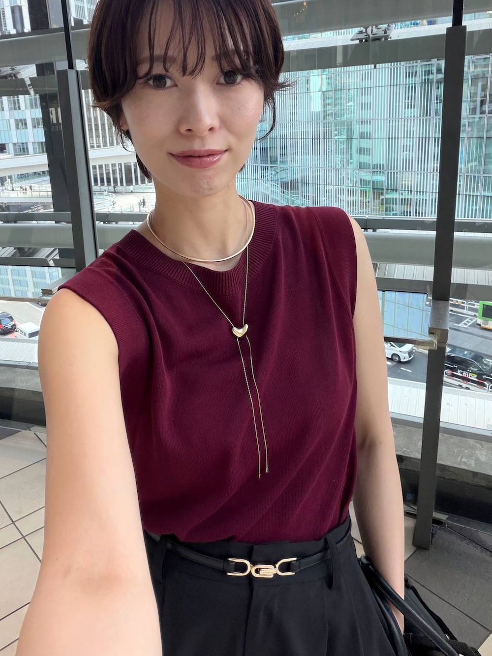レッド系のニット/セーター、ブラック系のその他パンツ、ブラック系のハンドバッグを着用したレディースの夏コーディネートの5枚目の写真