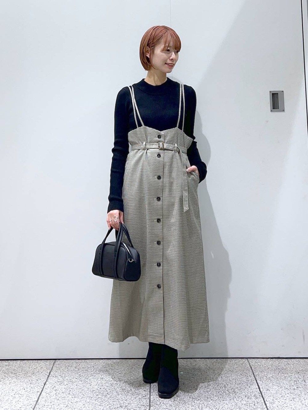 ブラック系のボストンバッグ、ブラック系のブーツ、ブラック系のニット/セーターを着用したレディースの冬コーディネートの4枚目の写真