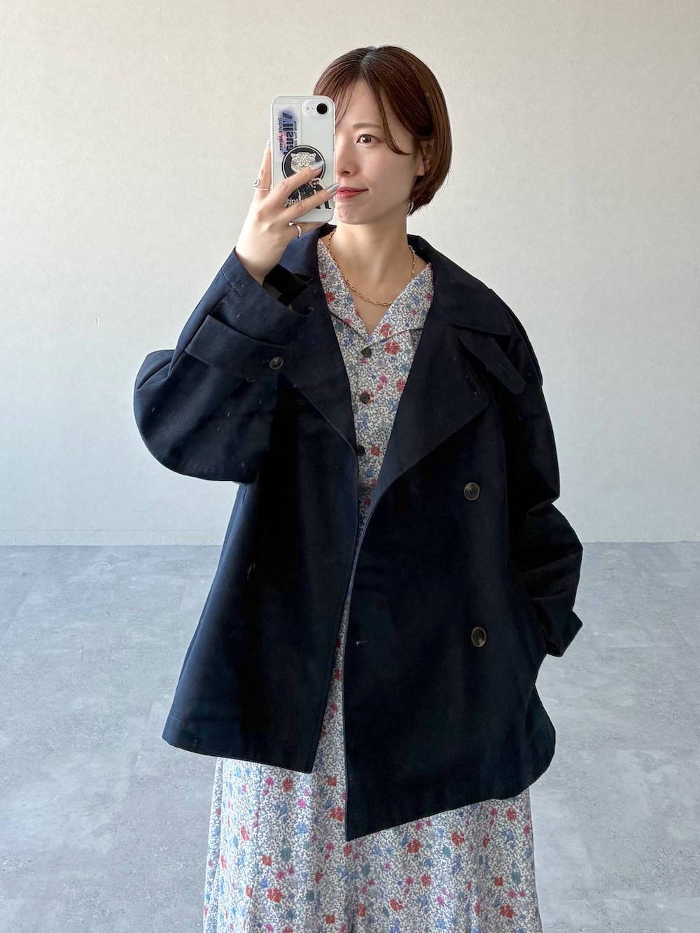 ブラック系のショルダーバッグ、ブラック系のサンダル、ブルー系のトレンチコートを着用したレディースの冬コーディネートの7枚目の写真