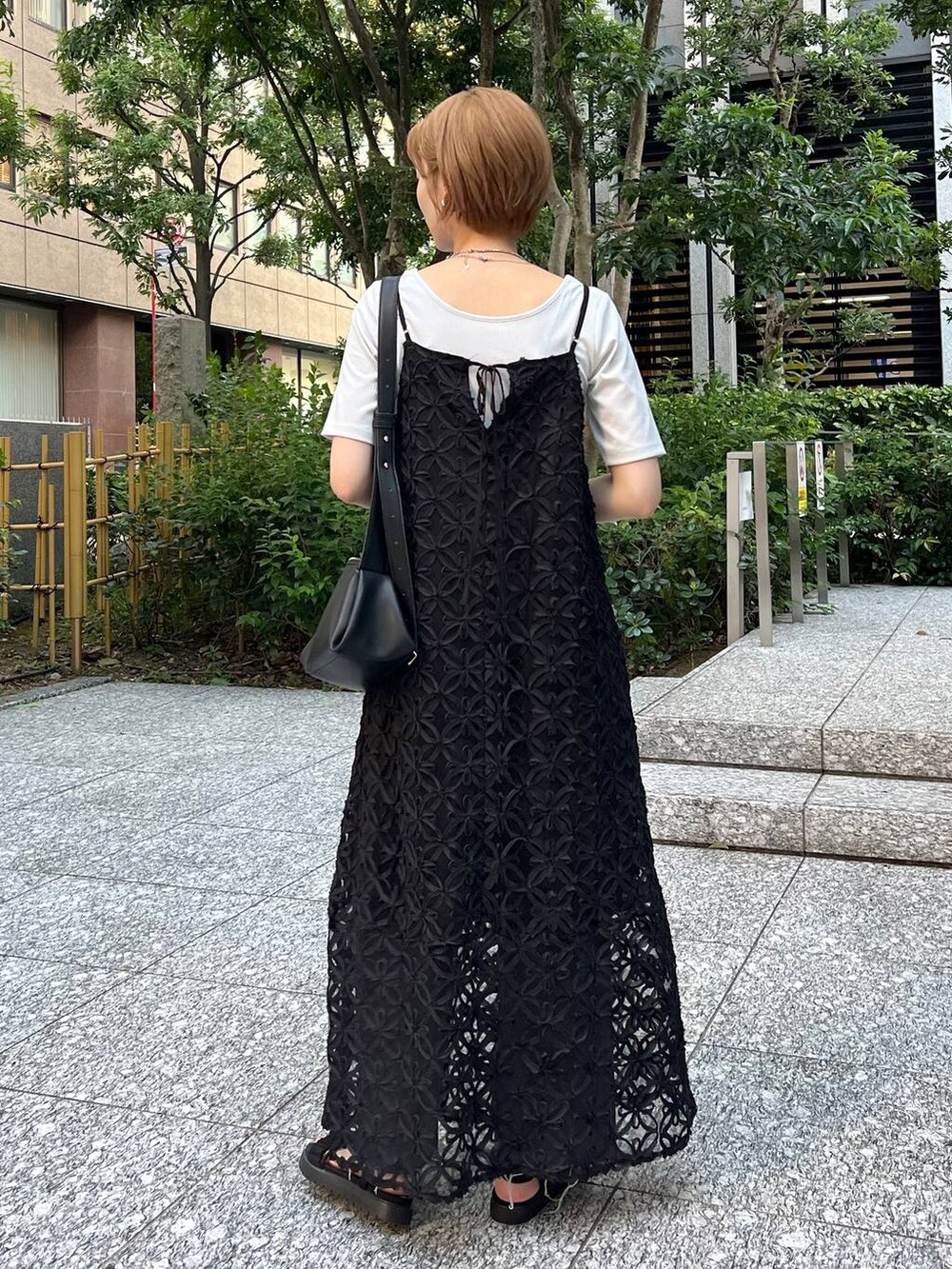 ブラック系のサンダル、ブラック系のショルダーバッグ、ホワイト系のTシャツ/カットソーを着用したレディースの夏コーディネートの3枚目の写真