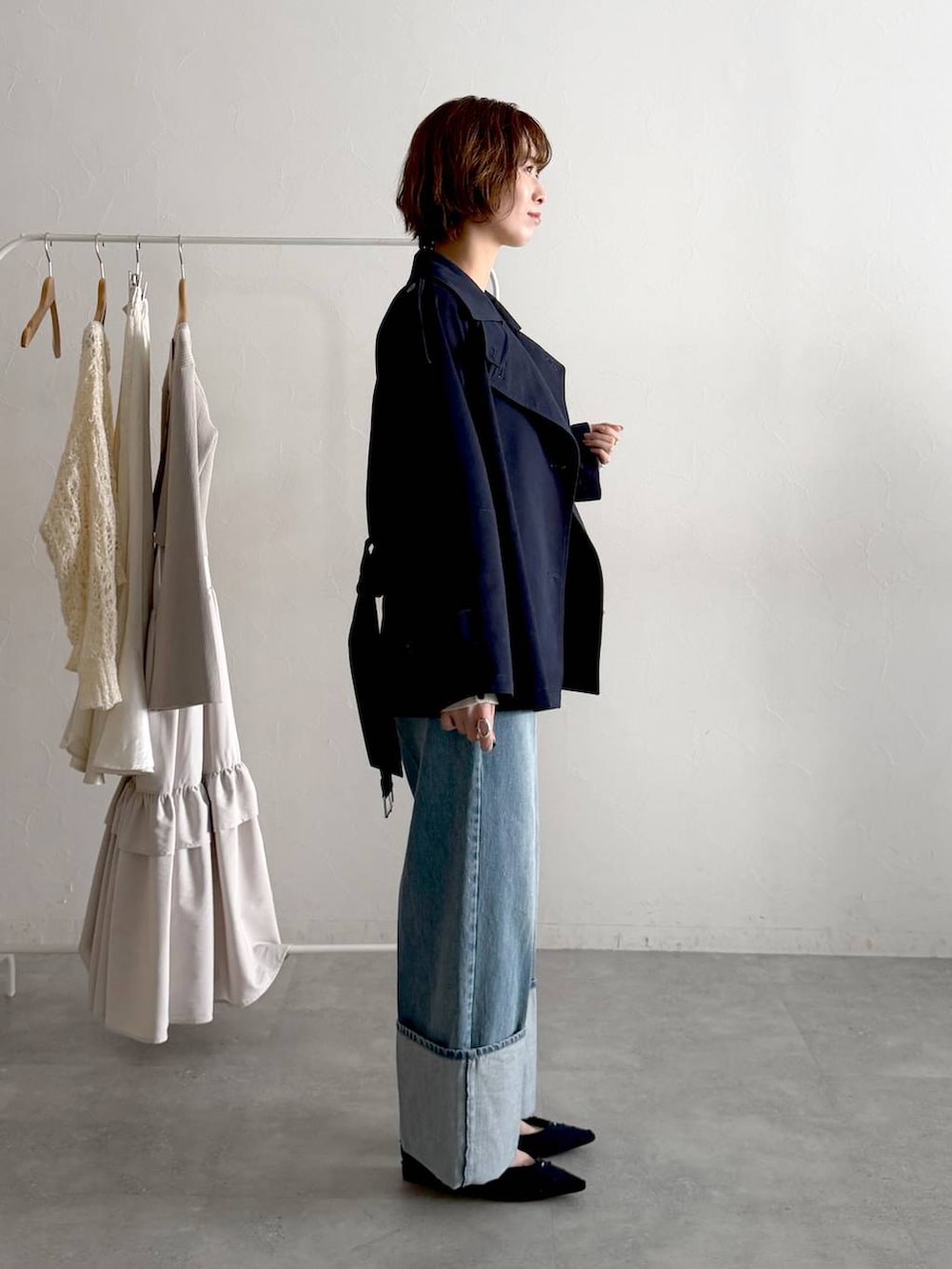 ブルー系のパンプス、ブルー系のトレンチコート、グレー系のニット/セーターを着用したレディースの春コーディネートの2枚目の写真