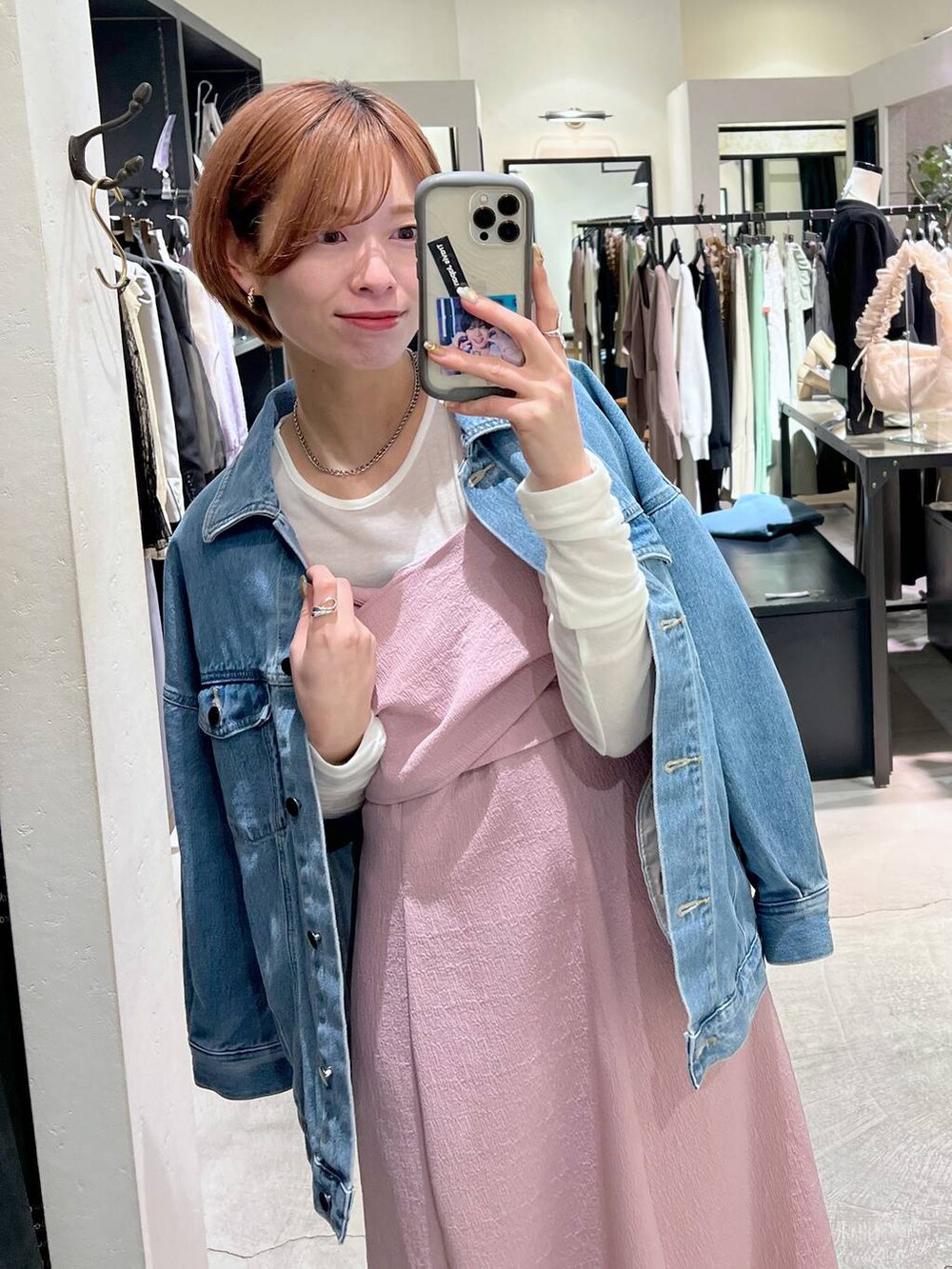 ベージュ系のショルダーバッグ、ブルー系のデニムジャケット、ホワイト系のバレエシューズを着用したレディースの春コーディネートの4枚目の写真