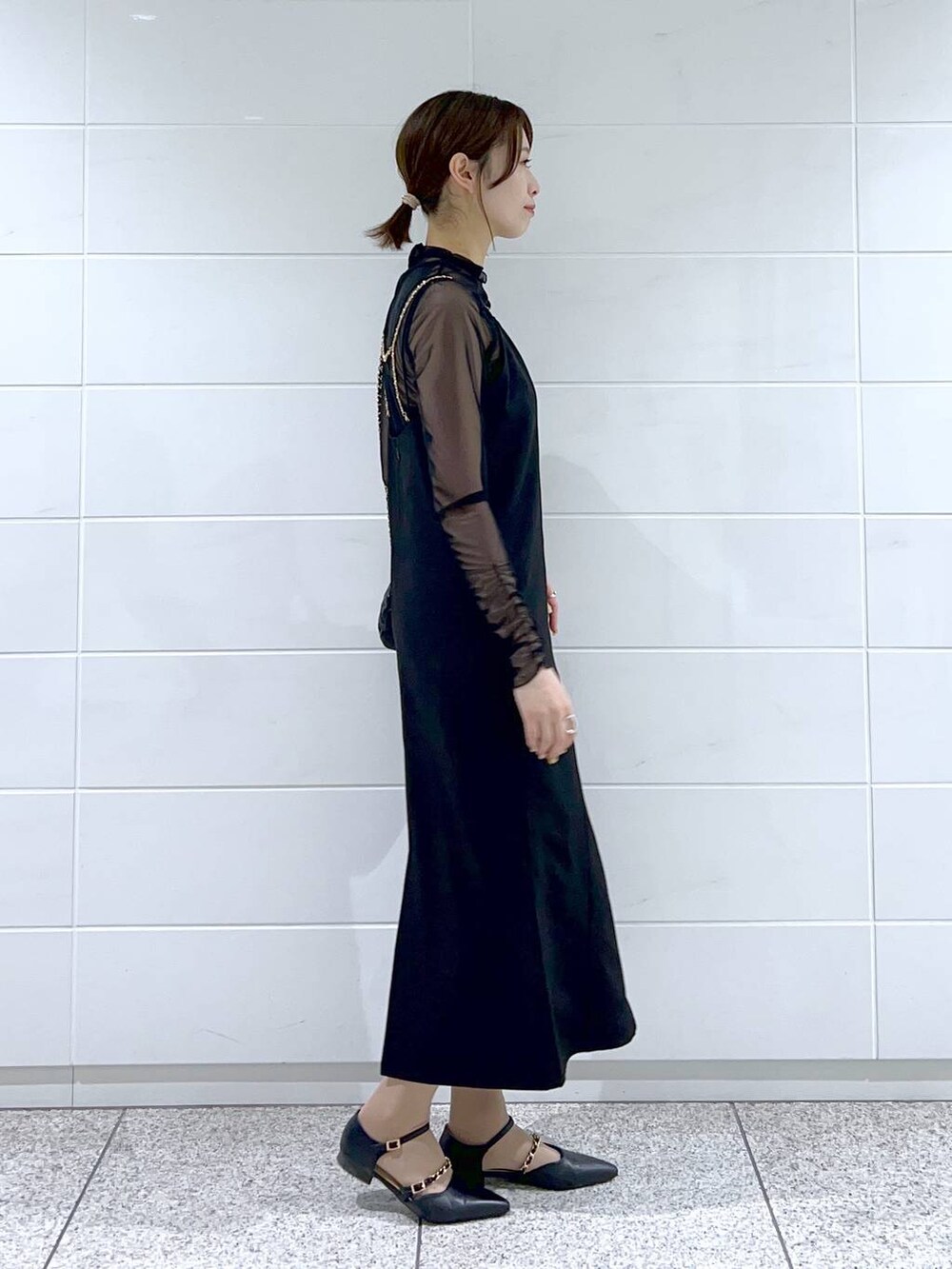 ブラック系のドレス、ブラック系のショルダーバッグ、ブラック系のパンプスを着用したレディースの春コーディネートの5枚目の写真