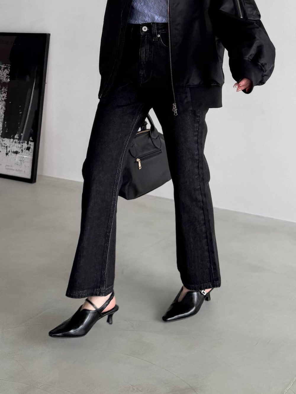 ブラック系のボストンバッグ、ブラック系のデニムパンツ、ブラック系のサンダルを着用したレディースの冬コーディネートの6枚目の写真