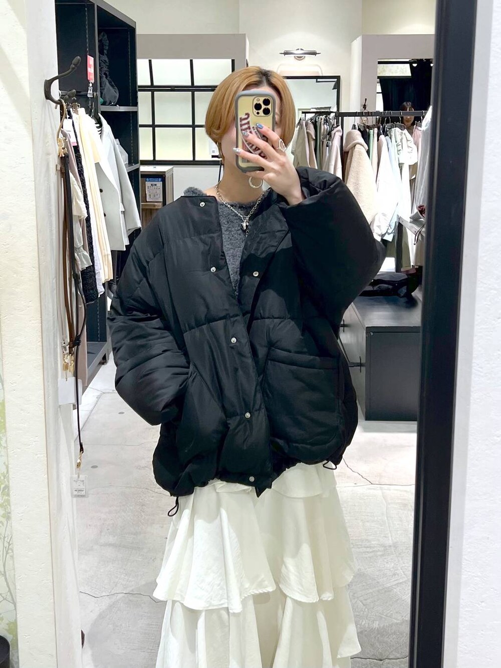 ブラック系のブーツ、ホワイト系のスカート、ブラック系のブルゾンを着用したレディースの冬コーディネートの7枚目の写真