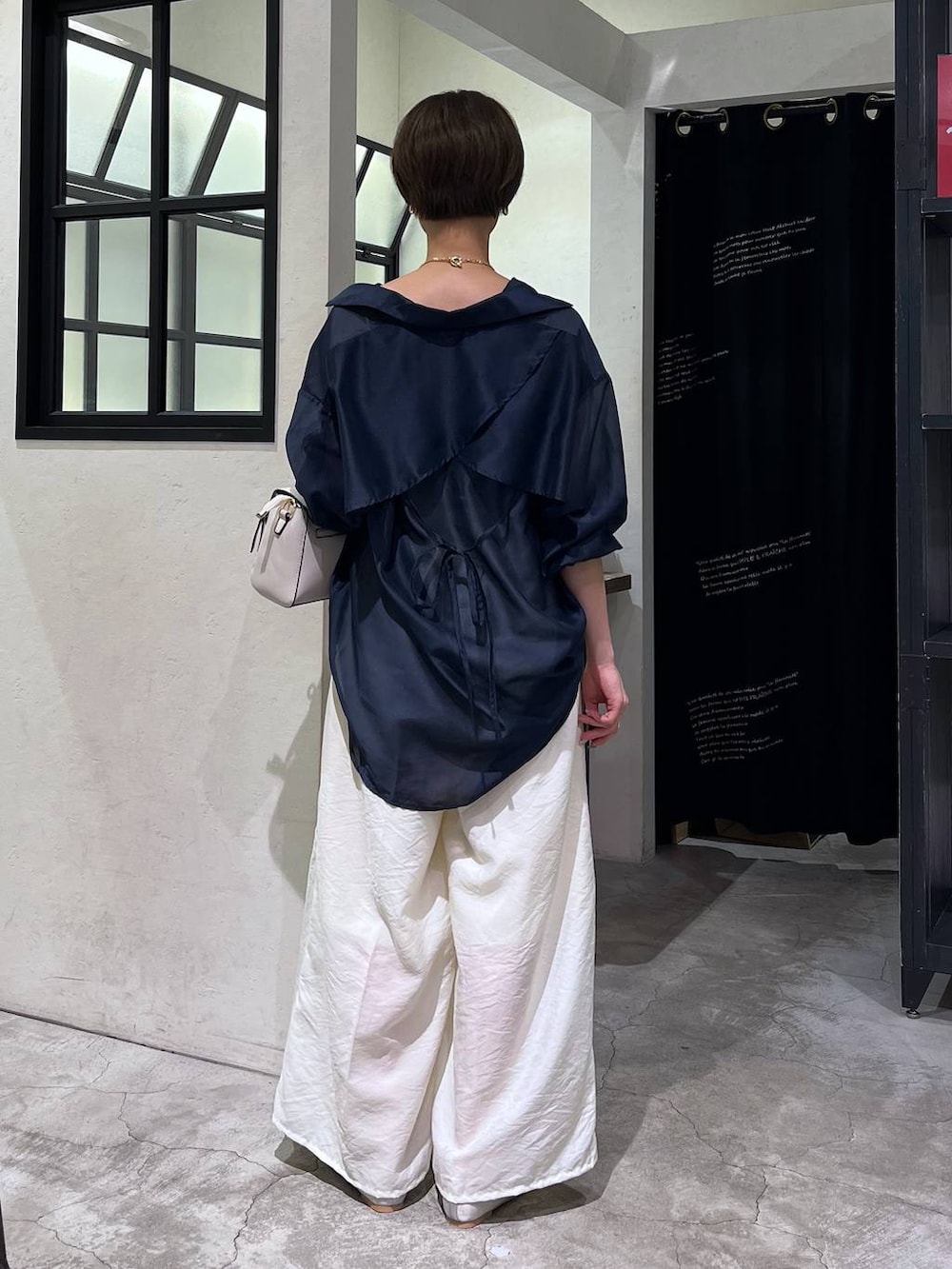 シルバー系のバレエシューズ、ホワイト系のショルダーバッグ、ホワイト系のキャミソールを着用したレディースの夏コーディネートの3枚目の写真