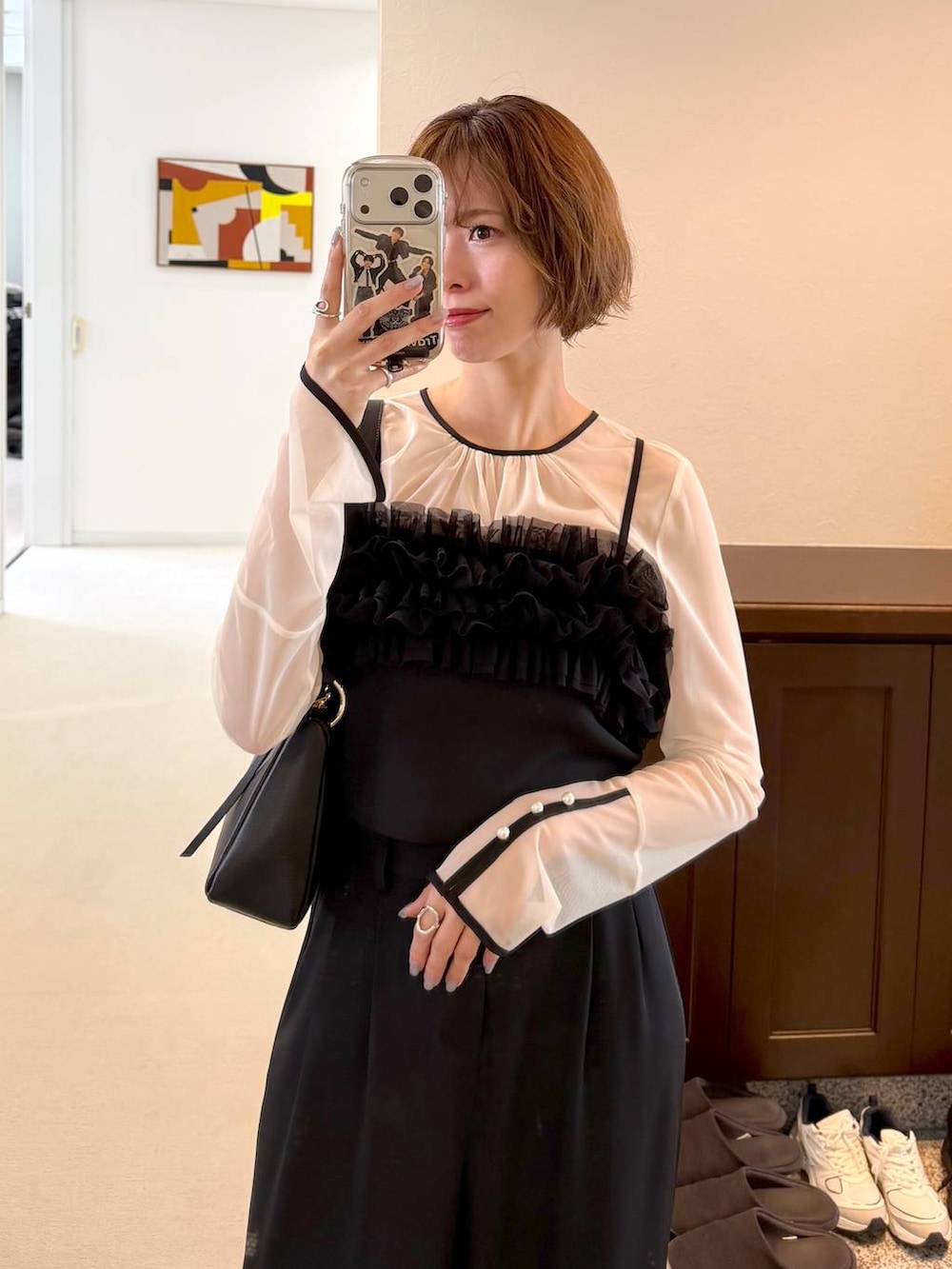 ブラック系のサンダル、ブラック系のショルダーバッグ、ブラック系のパンツドレスを着用したレディースの春コーディネートの7枚目の写真