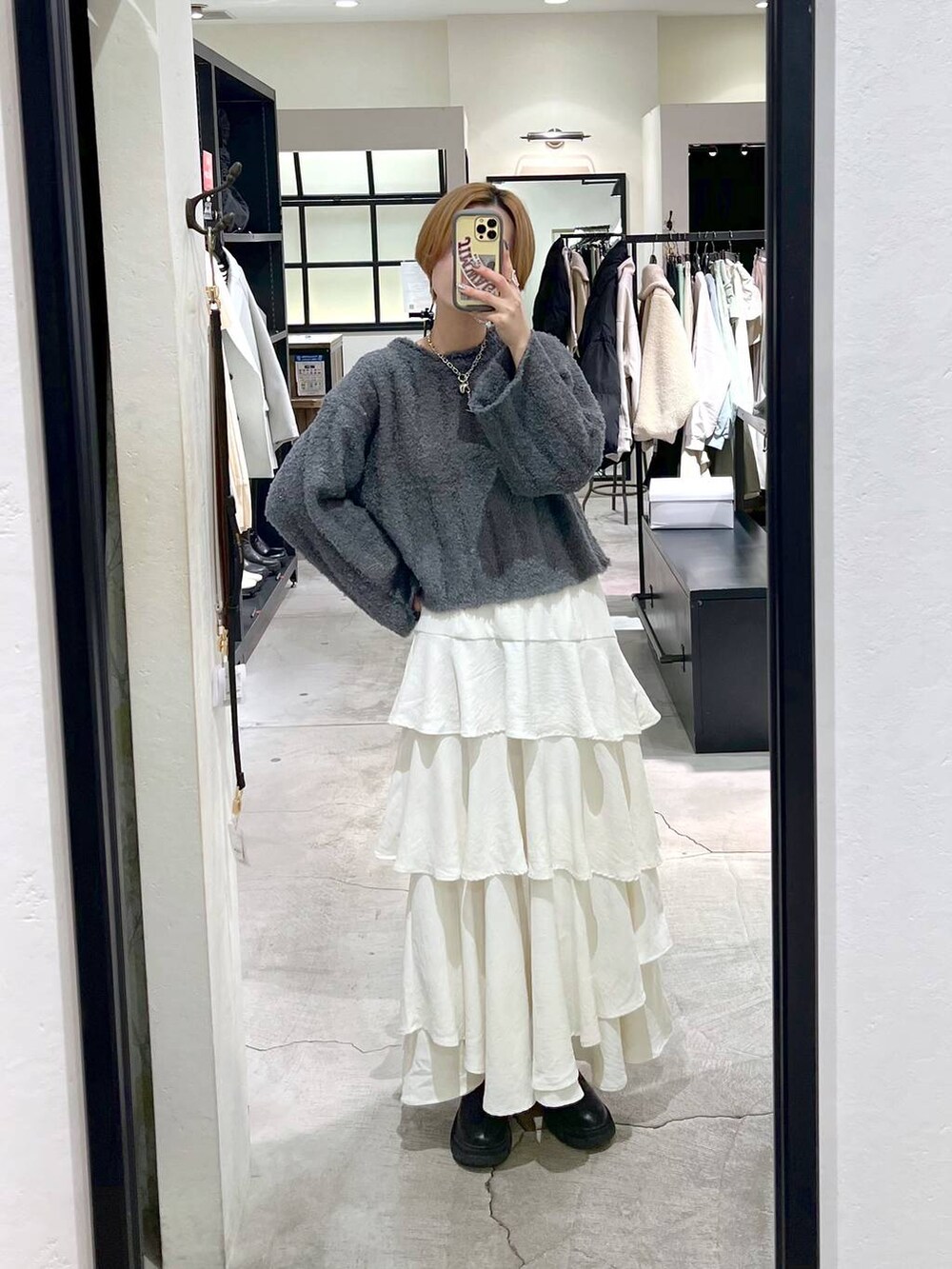 ブラック系のブーツ、ホワイト系のスカート、ブラック系のブルゾンを着用したレディースの冬コーディネートの8枚目の写真