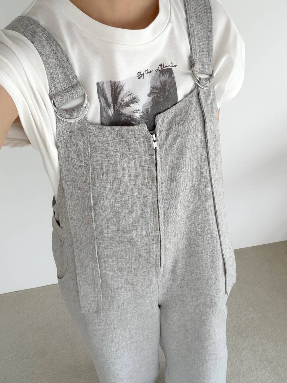 ブラック系のサンダル、ホワイト系のTシャツ/カットソー、グレー系のサロペット/オーバーオールを着用したレディースの春コーディネートの5枚目の写真