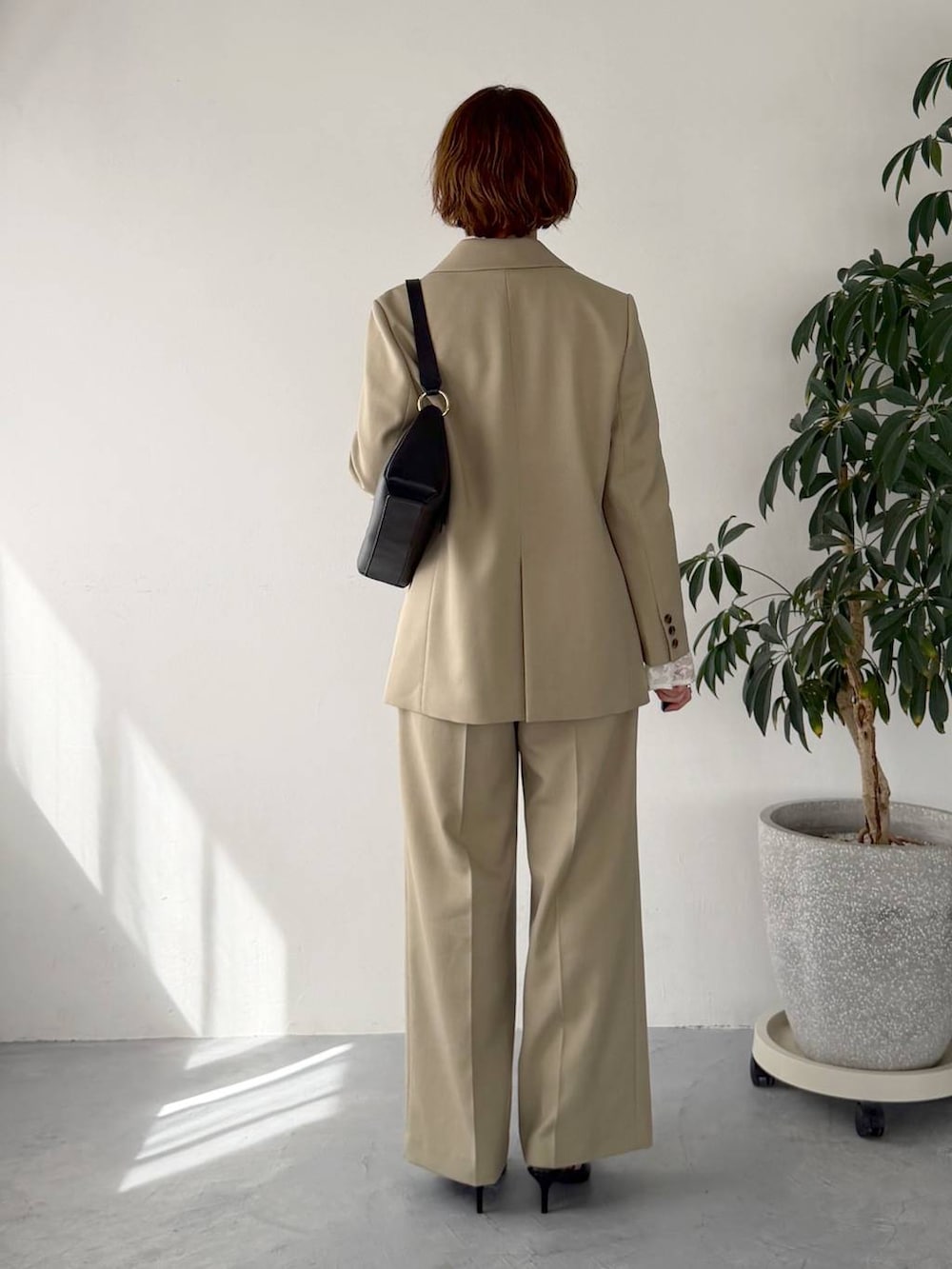 ベージュ系のテーラードジャケット、ベージュ系のその他パンツ、ブラック系のサンダルを着用したレディースの春コーディネートの3枚目の写真
