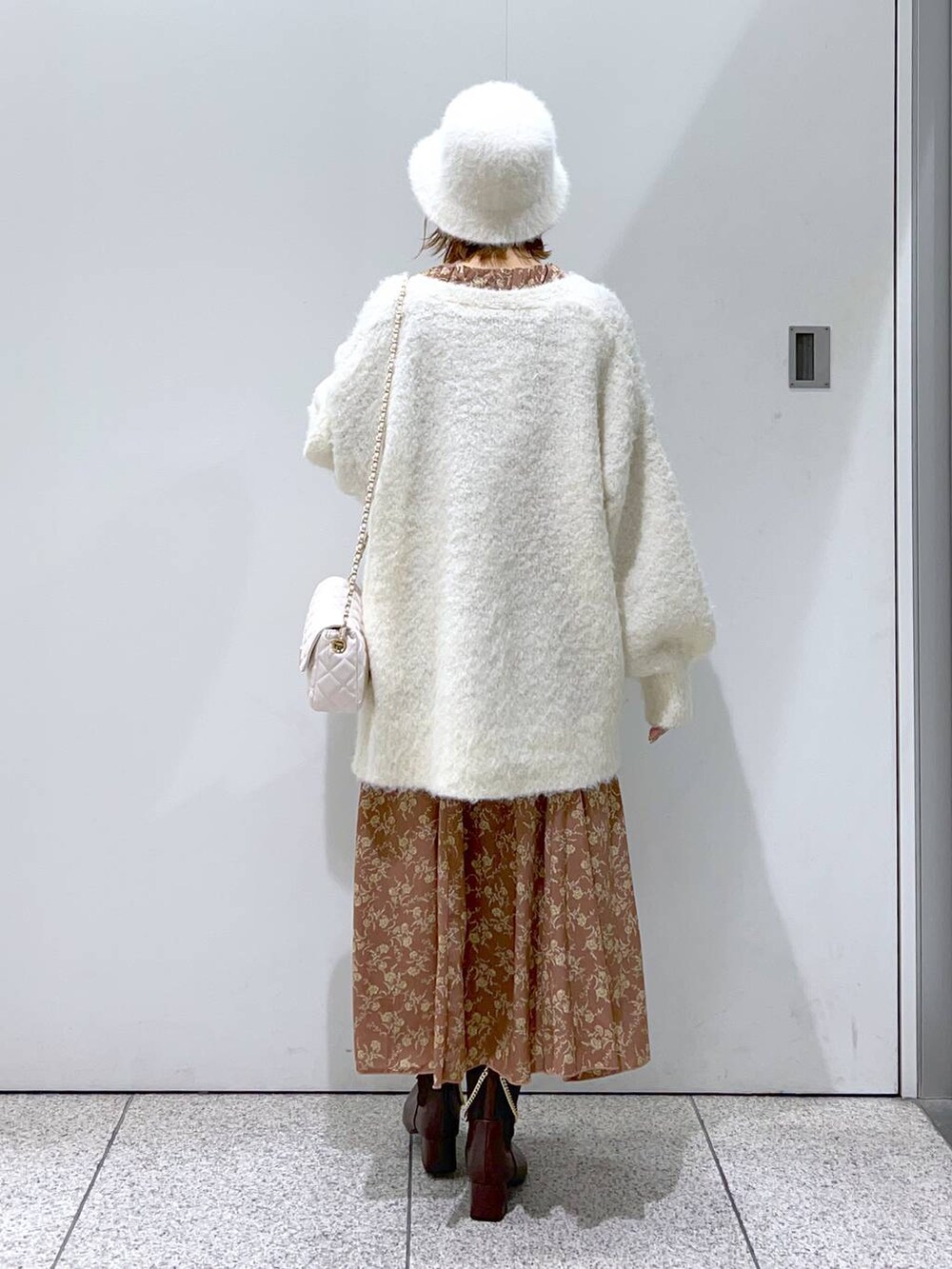 ホワイト系のショルダーバッグ、ホワイト系のカーディガン/ボレロ、ブラウン系のブーツを着用したレディースの秋コーディネートの4枚目の写真