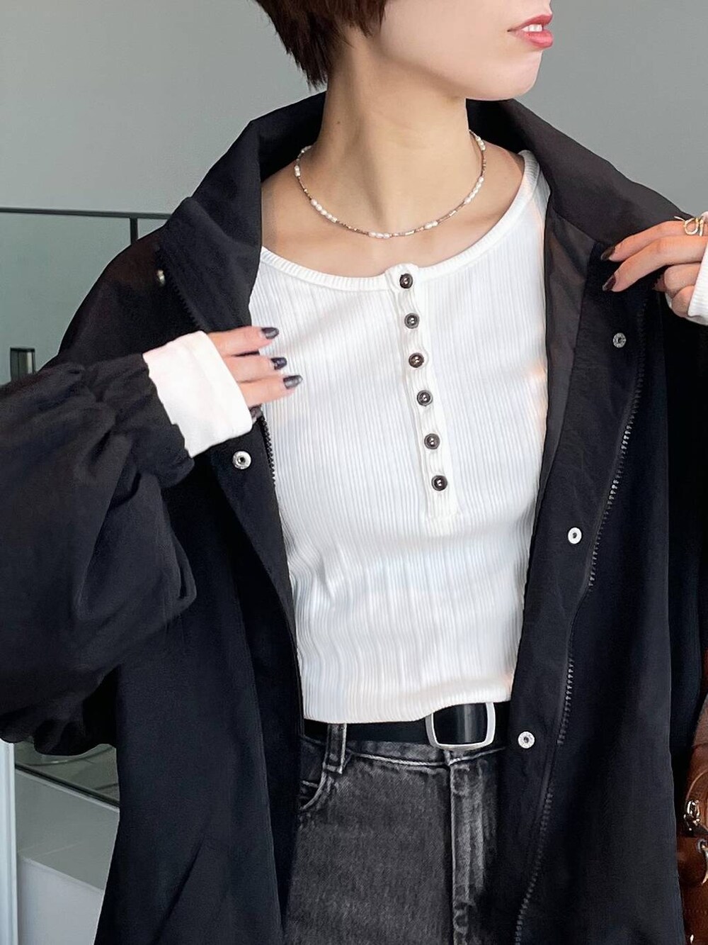 ブラウン系のボストンバッグ、ホワイト系のTシャツ/カットソー、ブラック系のブルゾンを着用したレディースの秋コーディネートの5枚目の写真