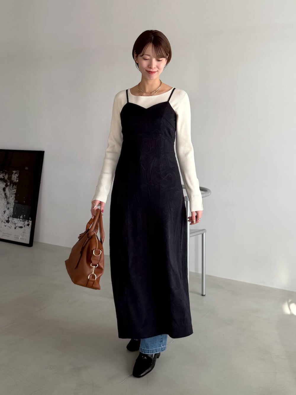 ブラウン系のボストンバッグ、ブラック系のローファー、ブルー系のデニムパンツを着用したレディースの冬コーディネートの5枚目の写真