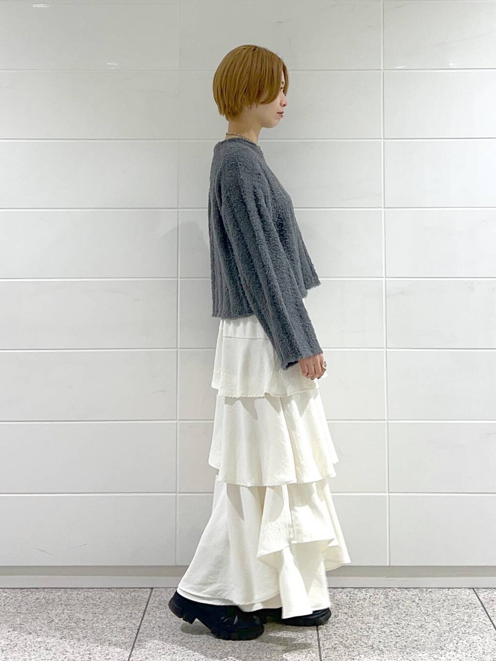 ブラック系のブーツ、ホワイト系のスカート、ブラック系のブルゾンを着用したレディースの冬コーディネートの5枚目の写真