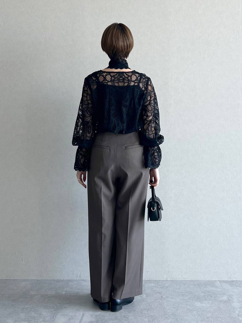 ブラック系のシャツ/ブラウス、ブラウン系のスラックス、ブラック系のローファーを着用したレディースの秋コーディネートの3枚目の写真