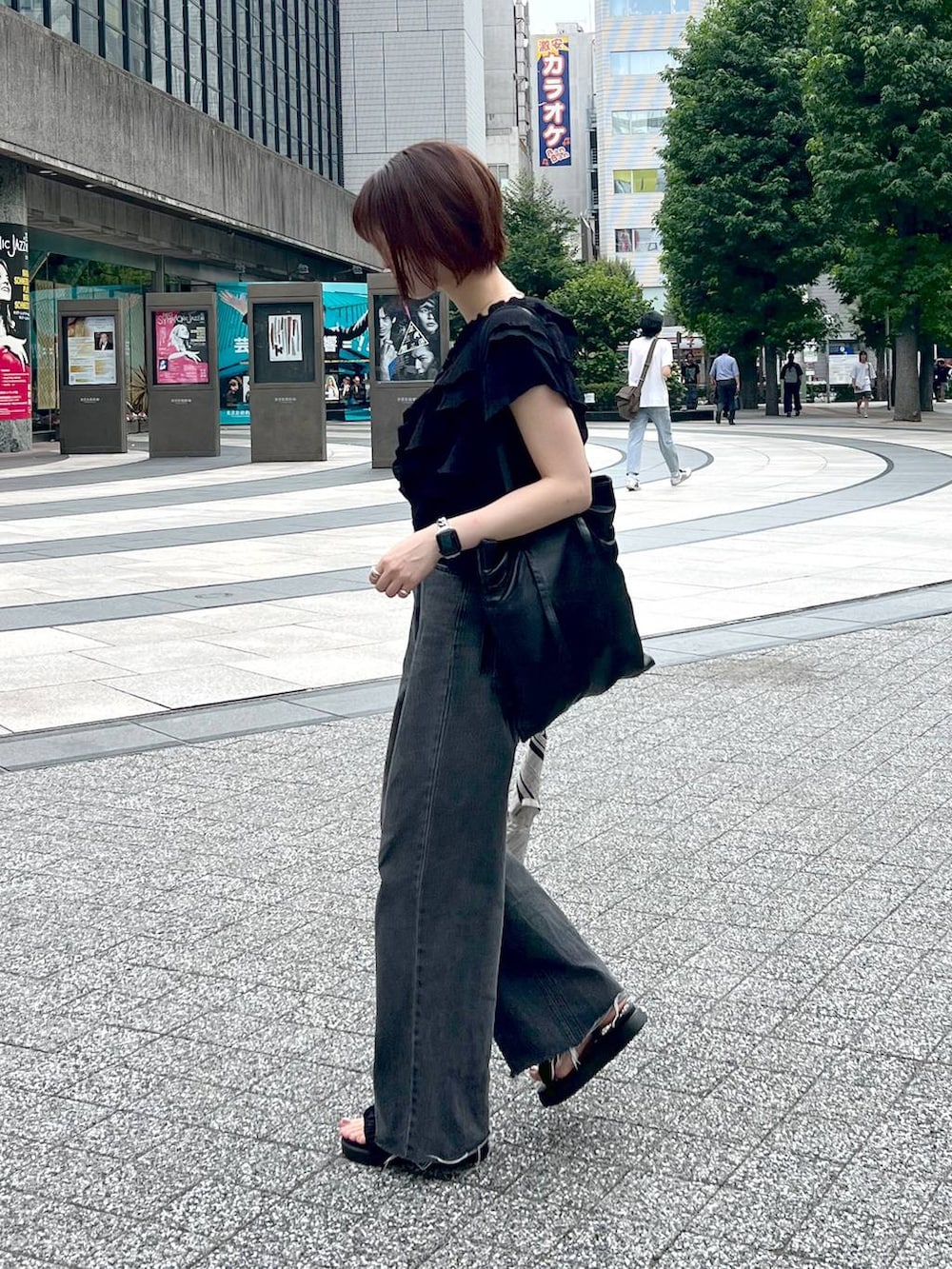 ブラック系のサンダル、ブラック系のシャツ/ブラウス、ブラック系のデニムパンツを着用したレディースの夏コーディネートの3枚目の写真