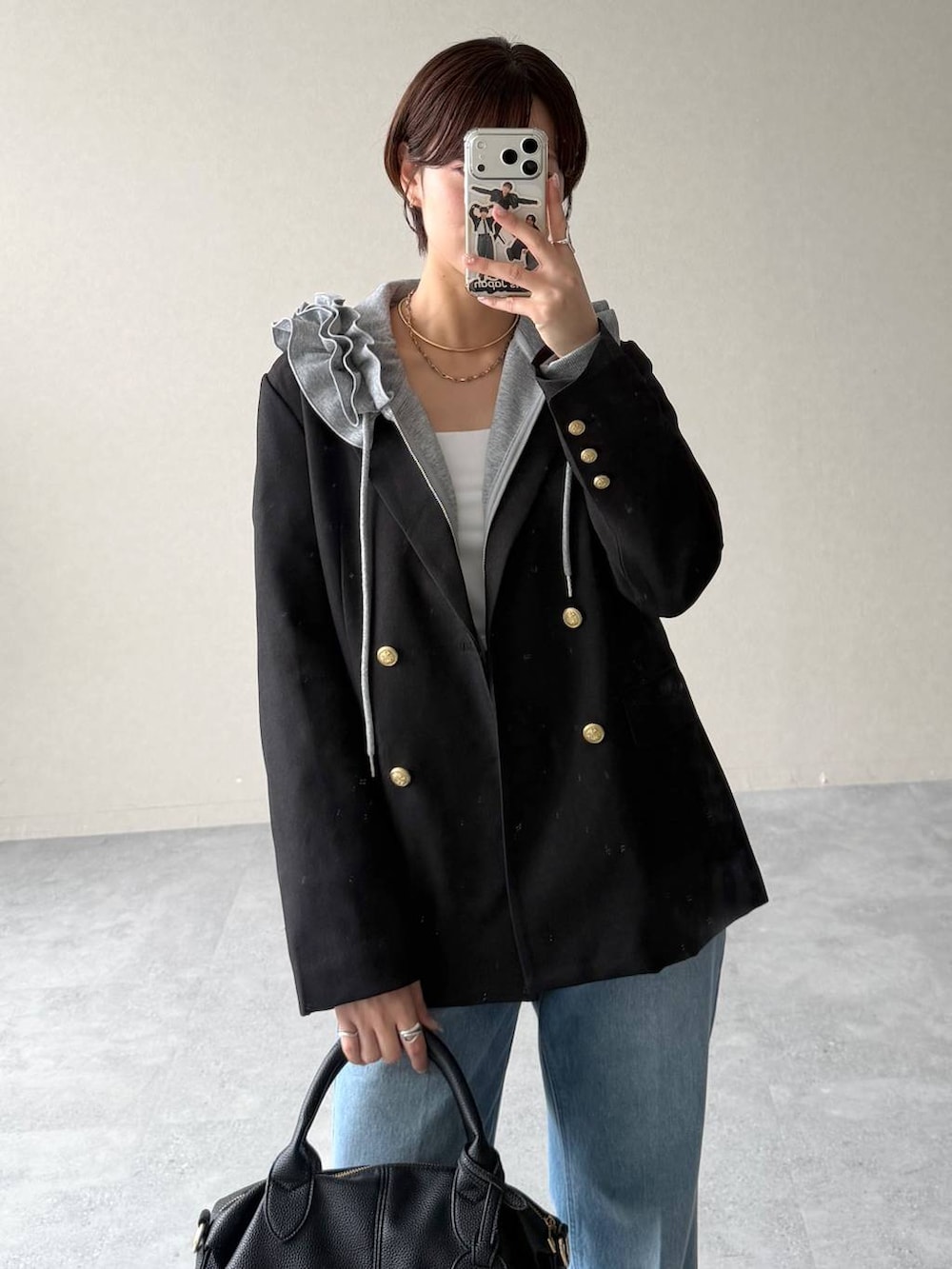 ブルー系のデニムパンツ、グレー系のパーカー、ブラック系のボストンバッグを着用したレディースの秋コーディネートの6枚目の写真