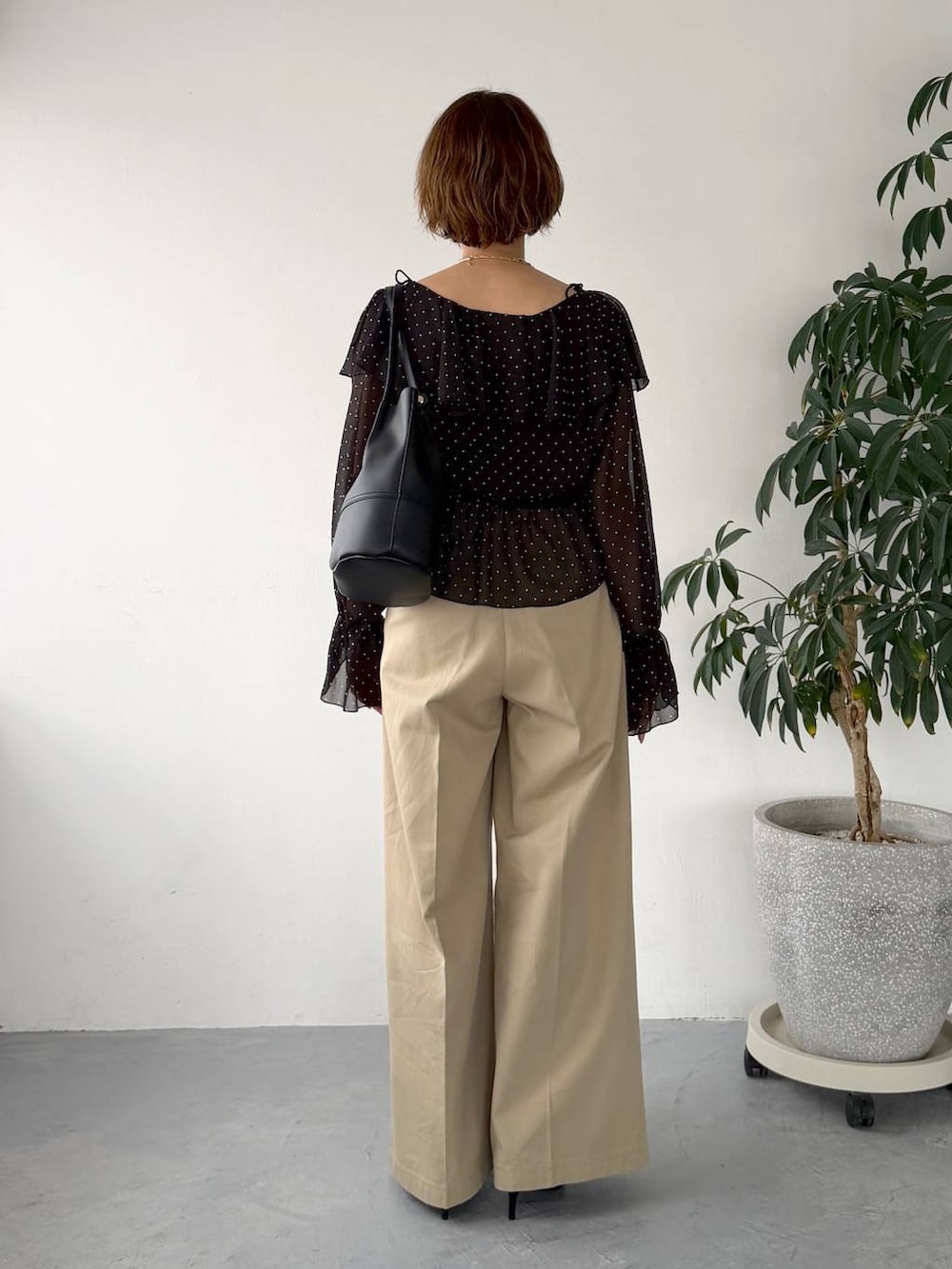 ブラック系のサンダル、ブラック系のシャツ/ブラウス、ベージュ系のチノパンツを着用したレディースの春コーディネートの3枚目の写真