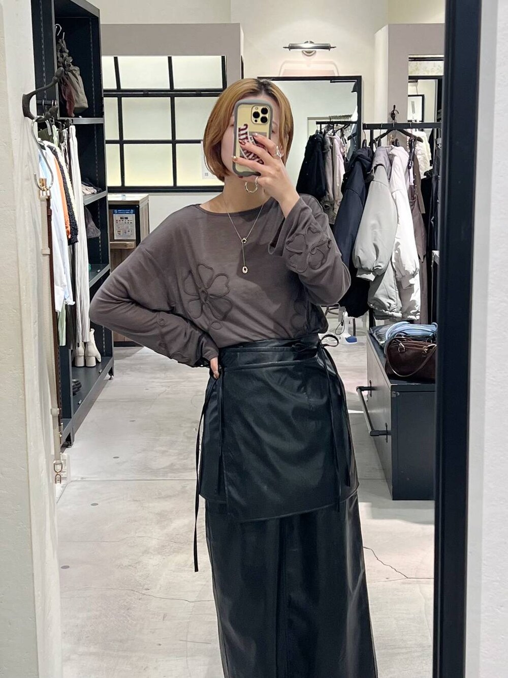 ブラック系のブーツ、グレー系のTシャツ/カットソー、ブラック系のスカートを着用したレディースの秋コーディネートの7枚目の写真