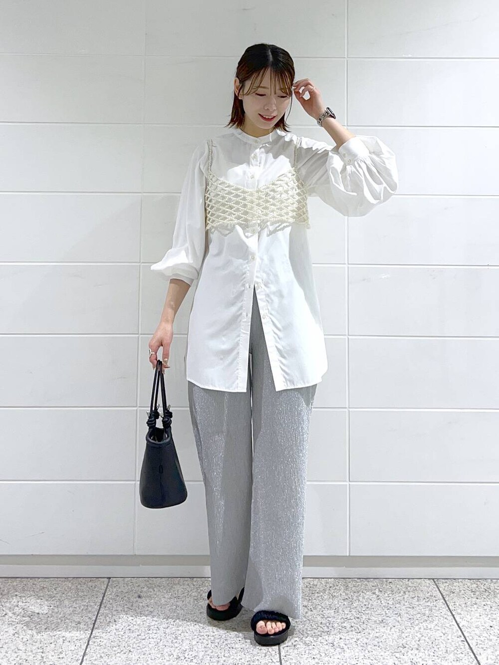 ホワイト系のシャツ/ブラウス、ホワイト系のベスト、ブラック系のサンダルを着用したレディースの春コーディネートの2枚目の写真