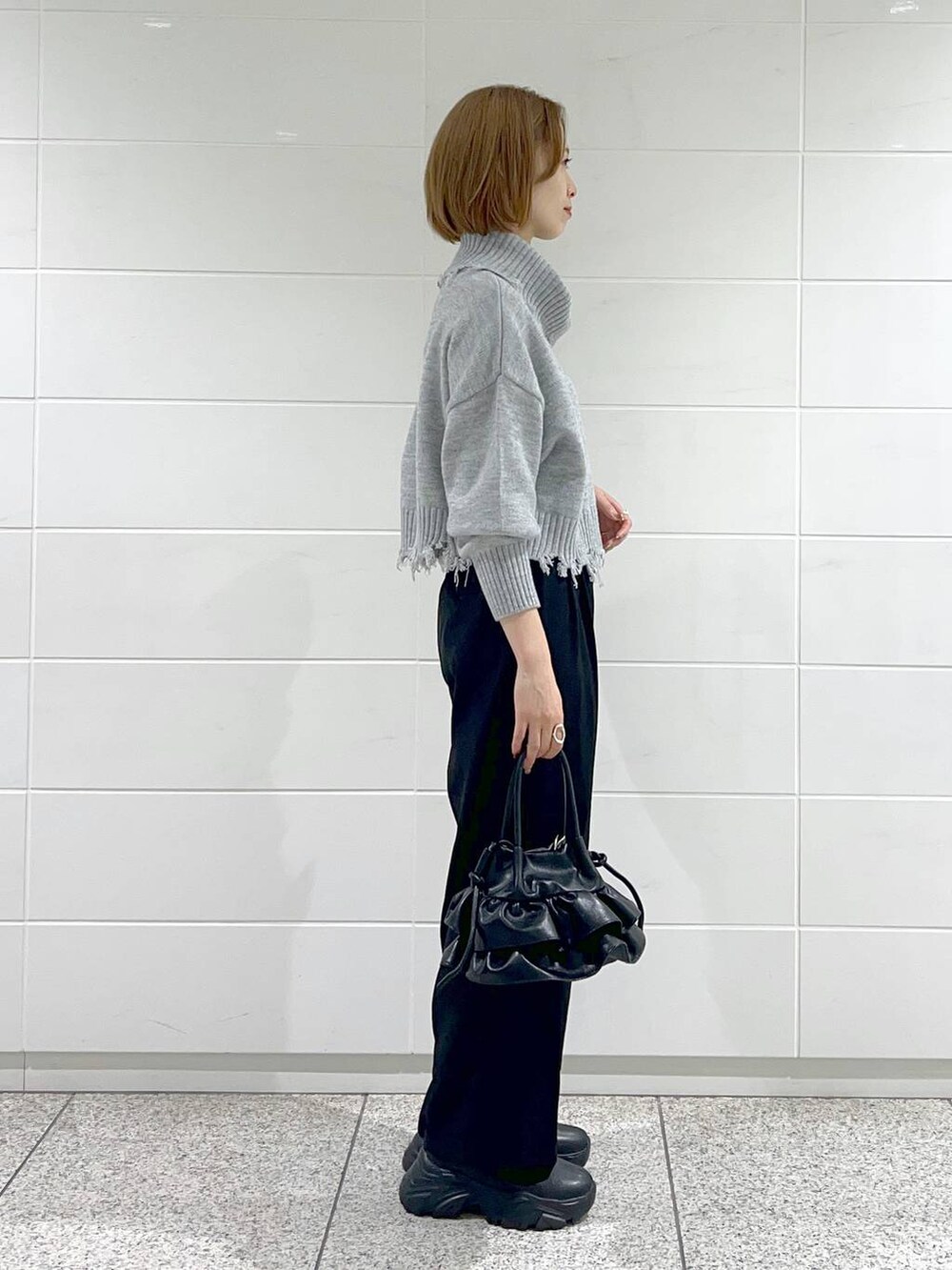 ブラック系のブーツ、ブラック系のショルダーバッグ、ホワイト系のその他アウターを着用したレディースの秋コーディネートの5枚目の写真