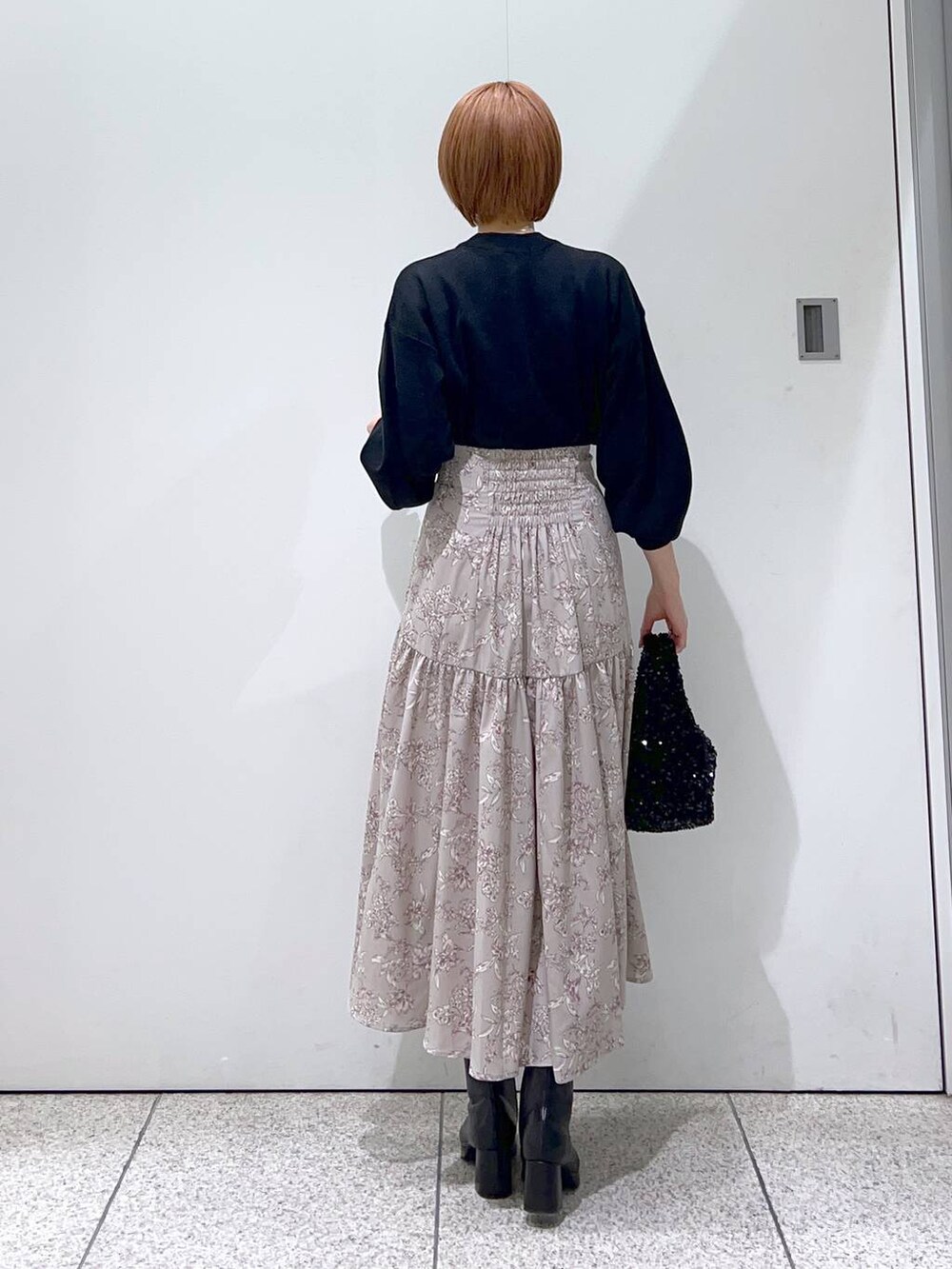 ブラック系のブーツ、ブラック系のニット/セーター、ブラック系のハンドバッグを着用したレディースの冬コーディネートの6枚目の写真