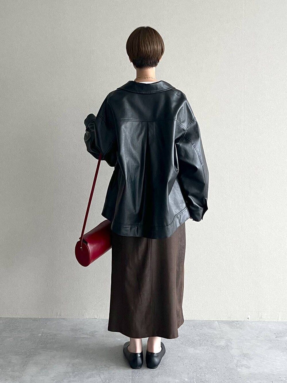 ブラック系のブルゾン、レッド系のショルダーバッグ、ブラック系のバレエシューズを着用したレディースの秋コーディネートの3枚目の写真