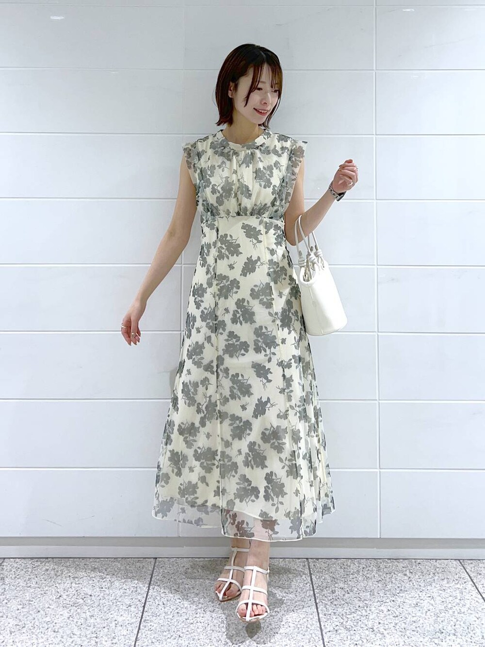 ホワイト系のハンドバッグ、ホワイト系のワンピース、ブルー系のデニムジャケットを着用したレディースの春コーディネートの5枚目の写真