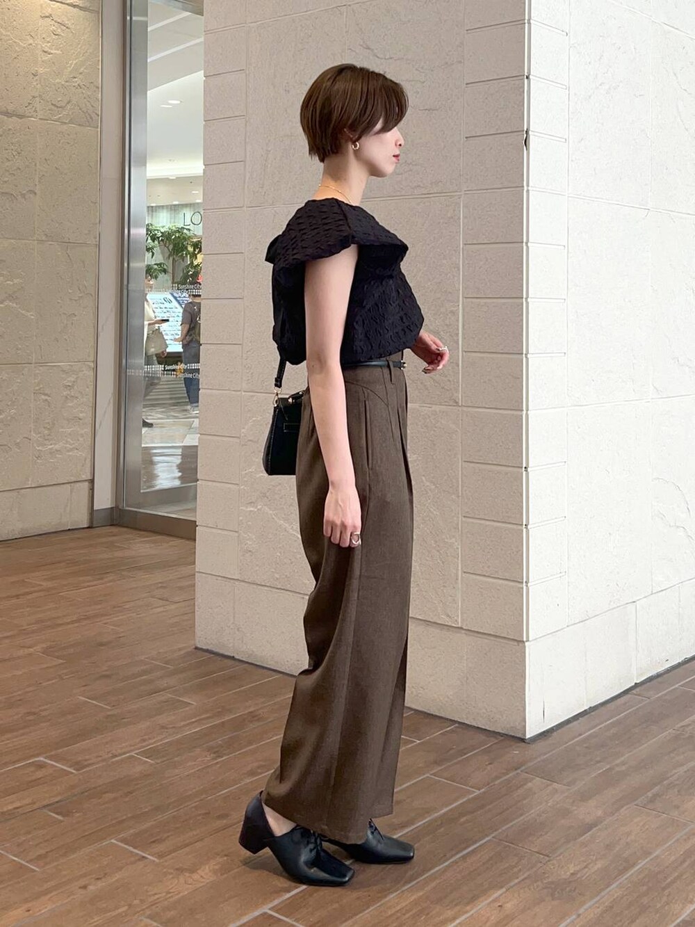 ブラック系のショルダーバッグ、ブラウン系のその他パンツ、ブラック系のドレスシューズを着用したレディースの夏コーディネートの2枚目の写真