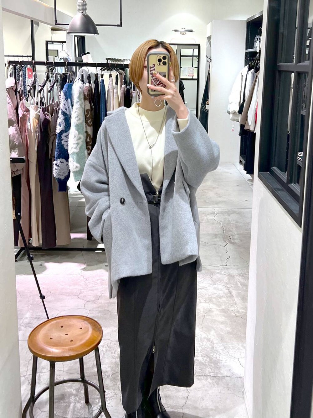 ブラック系のブーツ、ホワイト系のニット/セーター、ブラック系のショルダーバッグを着用したレディースの冬コーディネートの5枚目の写真