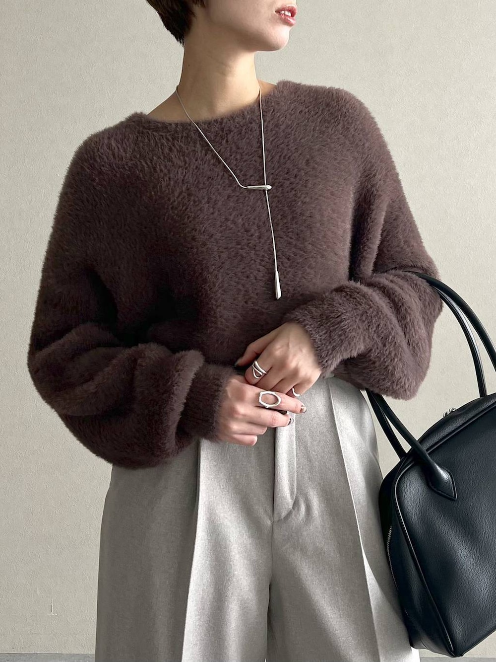 ブラック系のローファー、ブラック系のトートバッグ、ブラウン系のニット/セーターを着用したレディースの秋コーディネートの4枚目の写真