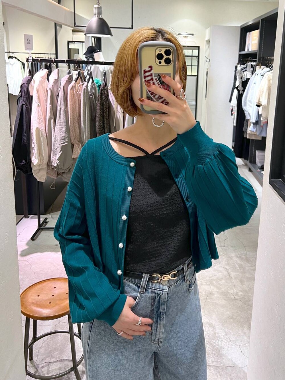 ブルー系のデニムパンツ、ブラック系のショルダーバッグ、ブラック系のブーツを着用したレディースの秋コーディネートの5枚目の写真