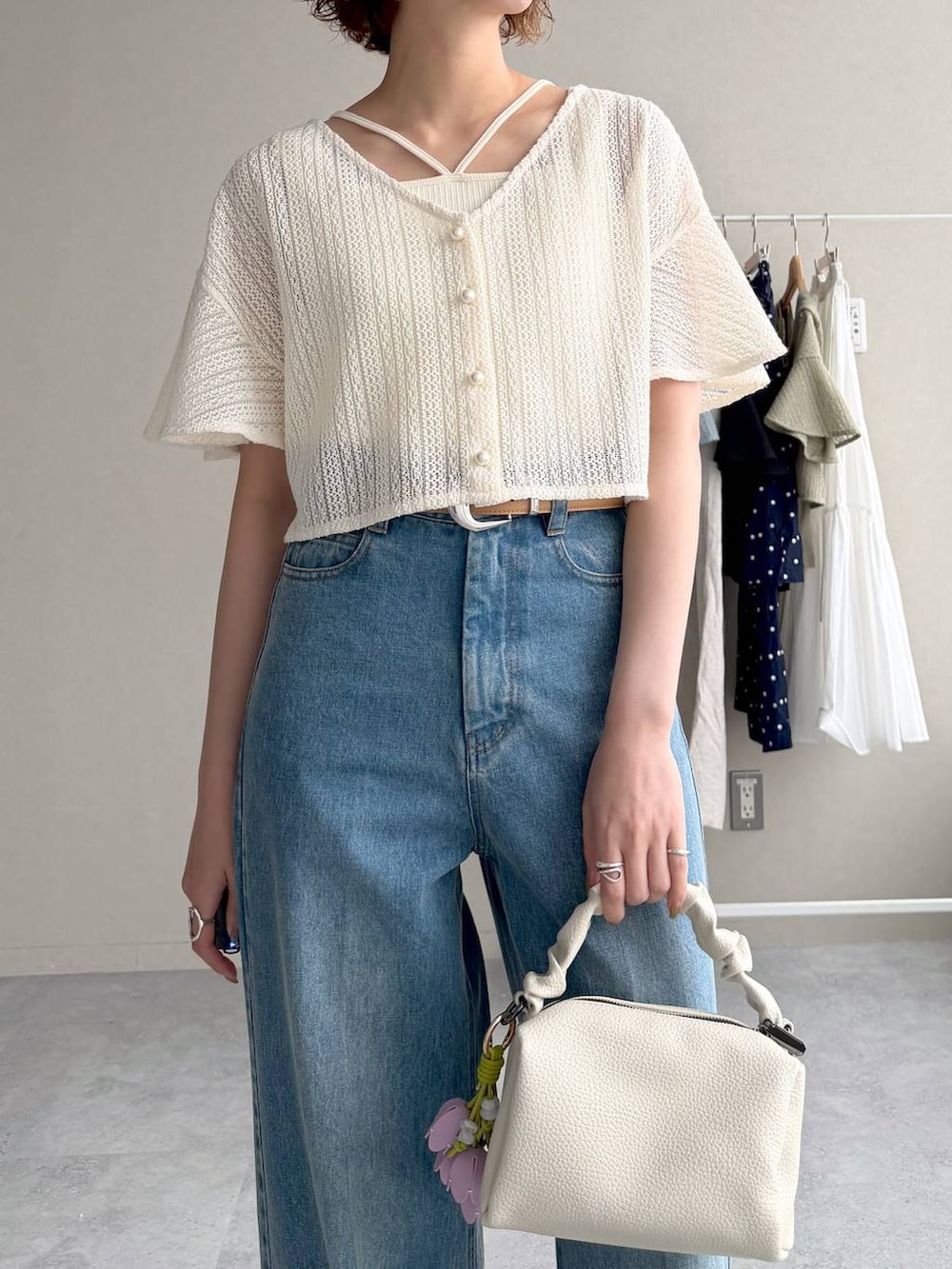 ホワイト系のカーディガン/ボレロ、ブルー系のデニムパンツ、ブラック系のサンダルを着用したレディースの春コーディネートの4枚目の写真