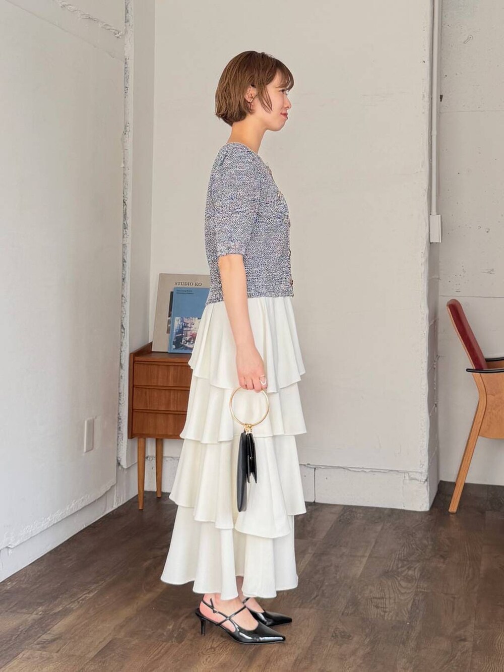 ホワイト系のスカート、ブラック系のサンダル、ブラック系のショルダーバッグを着用したレディースの春コーディネートの2枚目の写真