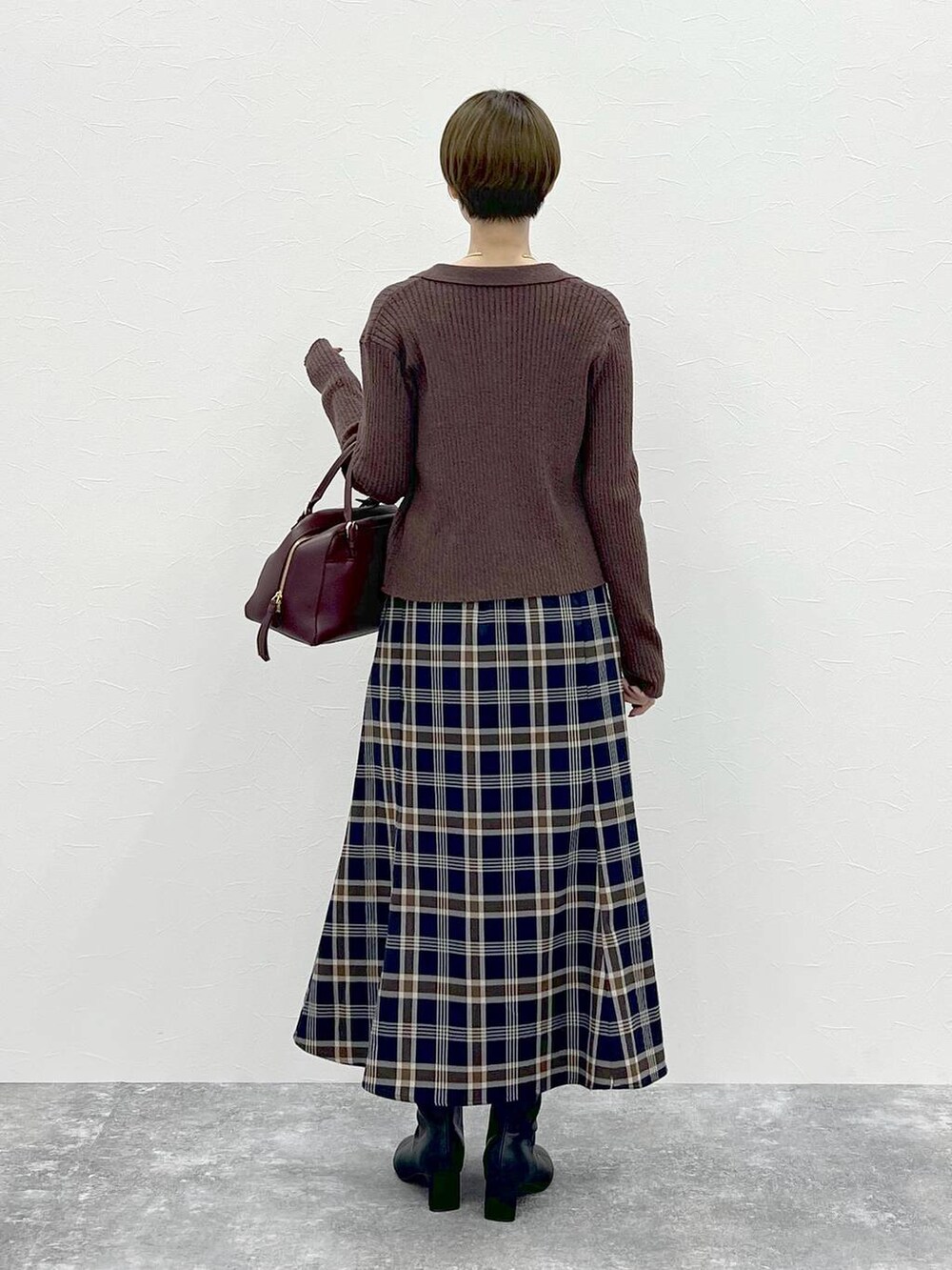 レッド系のハンドバッグ、ブラウン系のカーディガン/ボレロ、ブラウン系のニット/セーターを着用したレディースの秋コーディネートの3枚目の写真