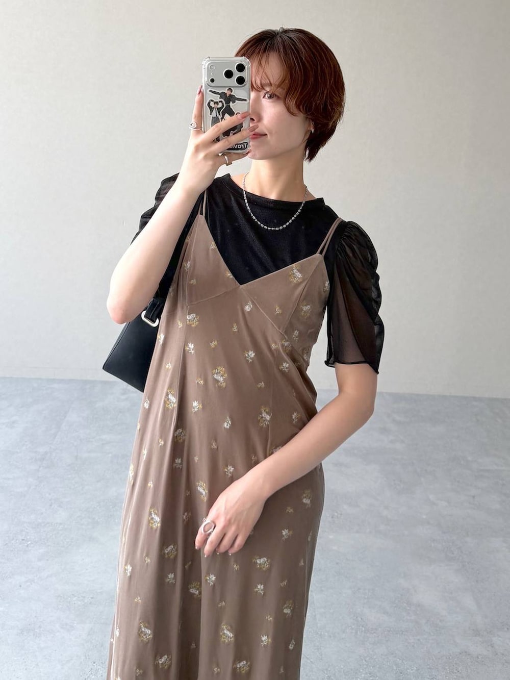 ブラック系のサンダル、ベージュ系のワンピース、ブラック系のTシャツ/カットソーを着用したレディースの夏コーディネートの6枚目の写真