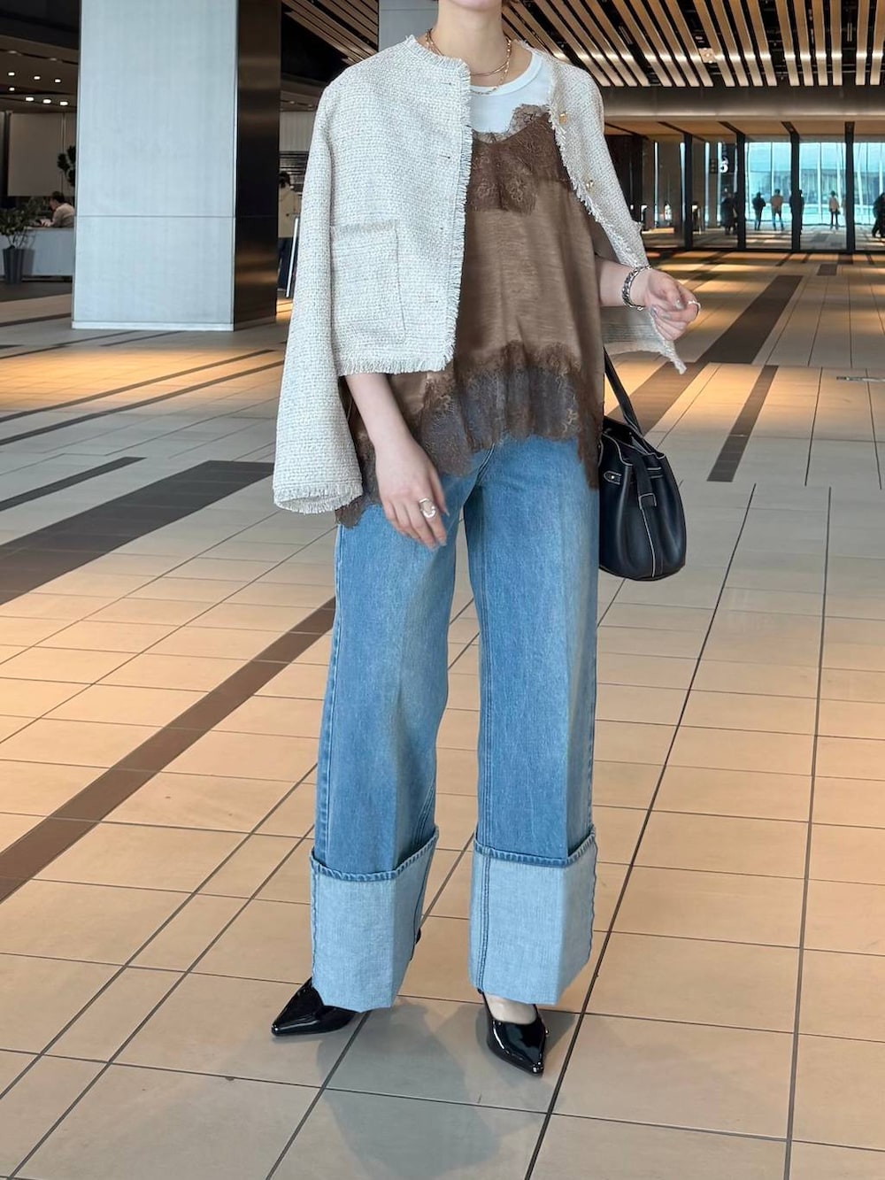 ブラック系のサンダル、ブラウン系のキャミソール、ホワイト系のノーカラージャケットを着用したレディースの春コーディネートの7枚目の写真