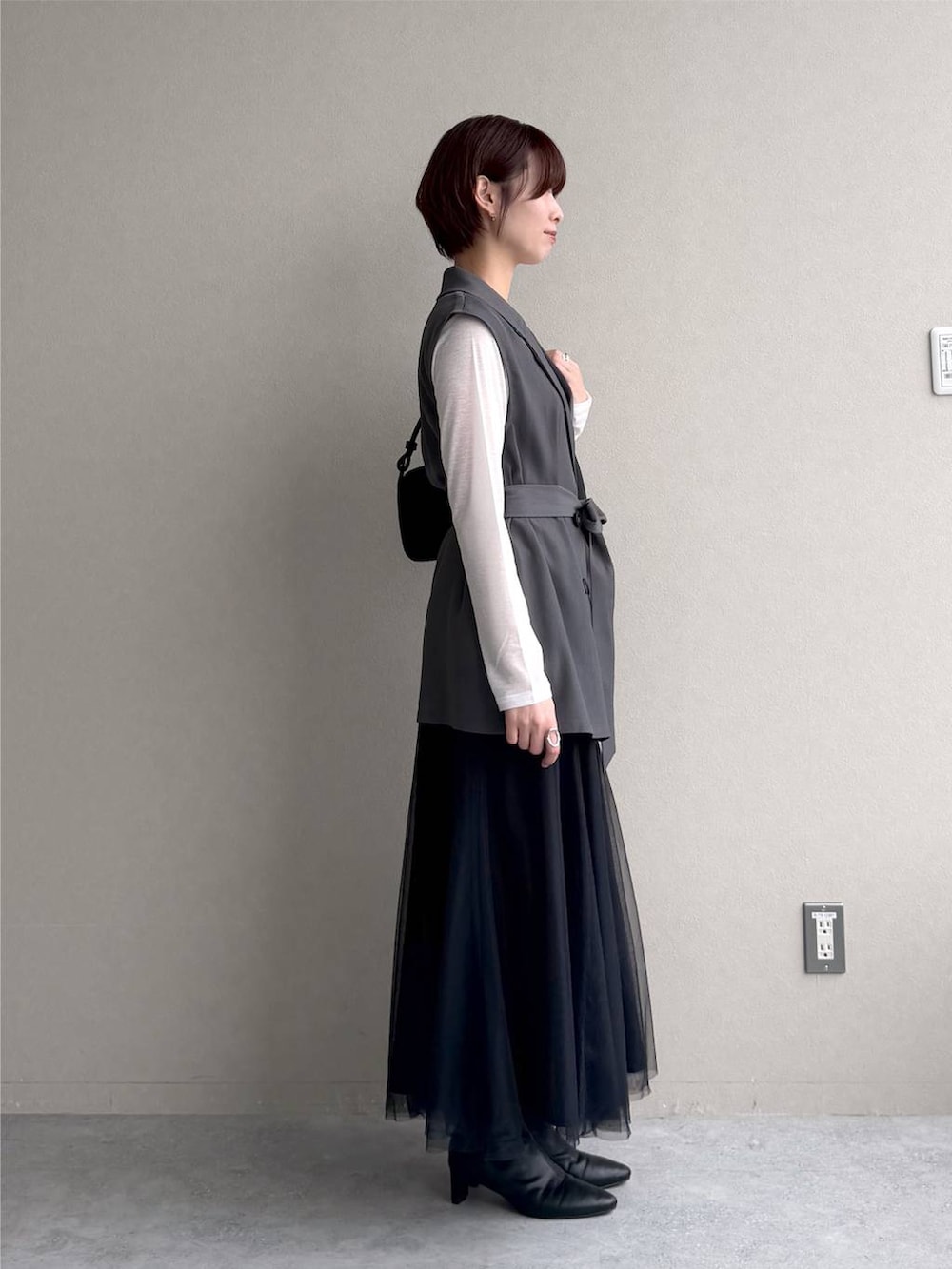ブラック系のワンピース、ホワイト系のTシャツ/カットソー、ブラック系のショルダーバッグを着用したレディースの秋コーディネートの2枚目の写真