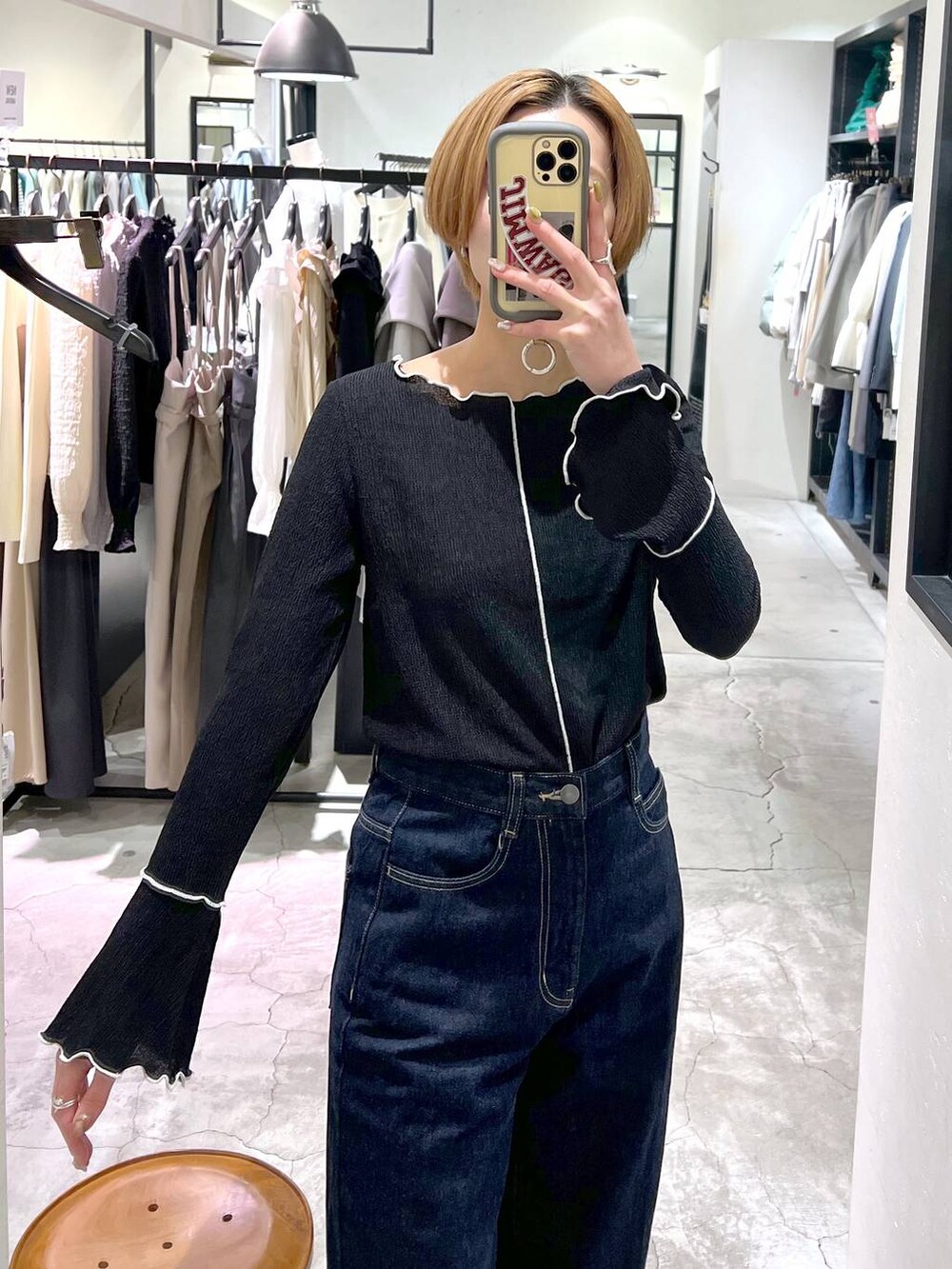 ホワイト系のブルゾン、ホワイト系のショルダーバッグ、ブルー系のスラックスを着用したレディースの冬コーディネートの8枚目の写真