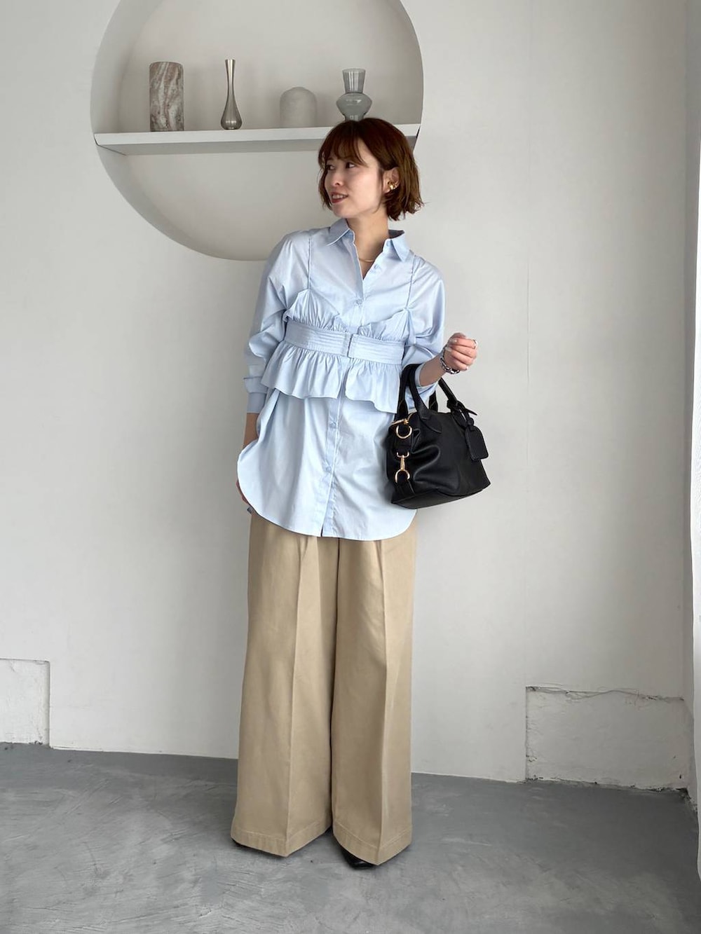 ブラック系のボストンバッグ、ブルー系のシャツ/ブラウス、ベージュ系のチノパンツを着用したレディースの春コーディネートの6枚目の写真