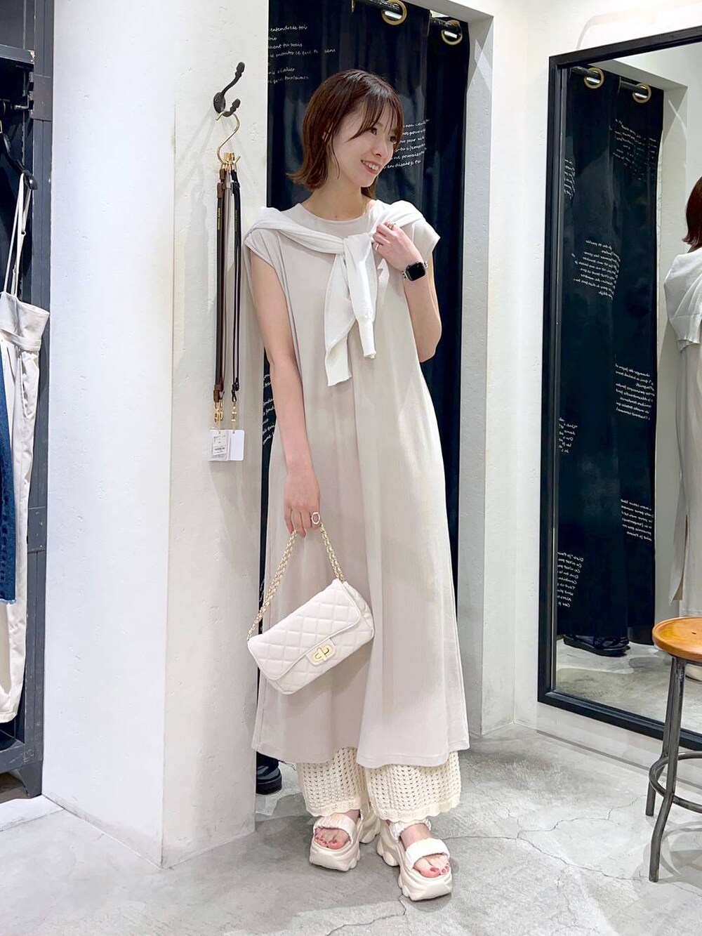 ホワイト系のカーディガン/ボレロ、ホワイト系のその他パンツ、ベージュ系のワンピースを着用したレディースの春コーディネートの2枚目の写真