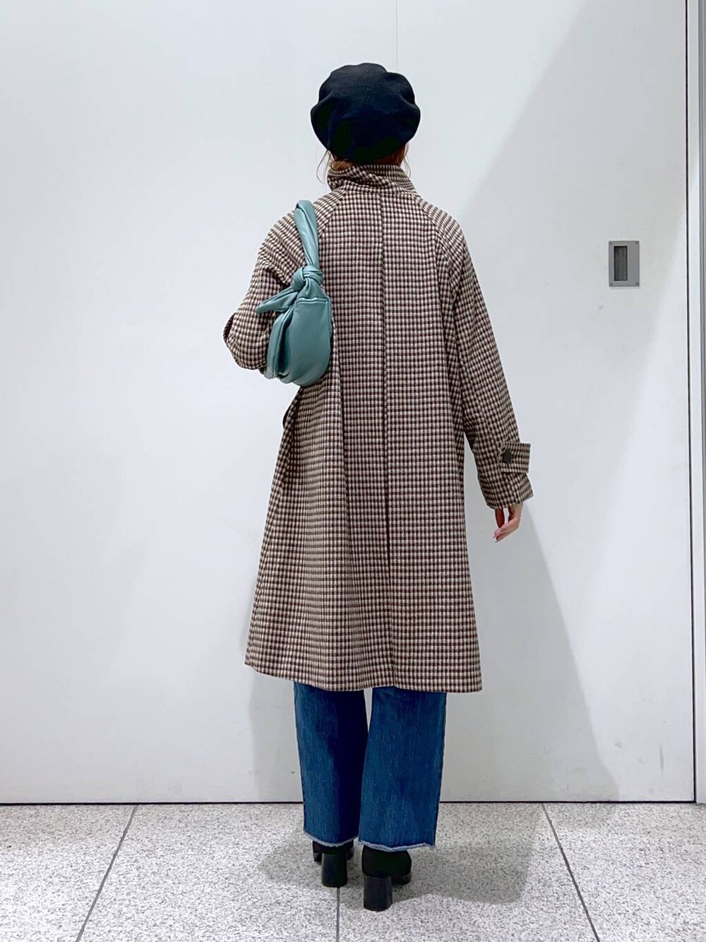 ブルー系のデニムパンツ、ブラック系のブーツ、ホワイト系のニット/セーターを着用したレディースの秋コーディネートの3枚目の写真