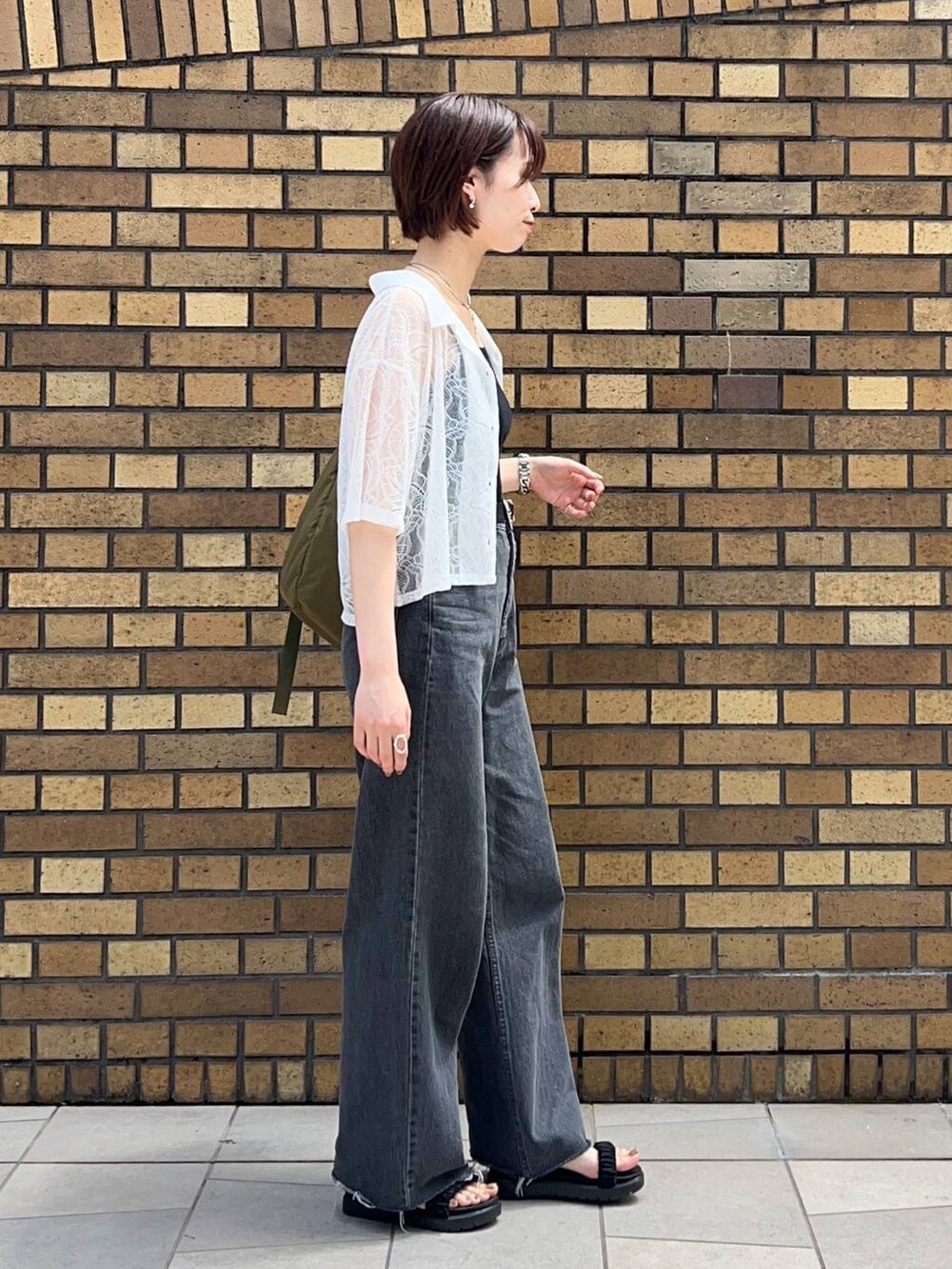 ブラック系のサンダル、ブラック系のタンクトップ、ホワイト系のシャツ/ブラウスを着用したレディースの夏コーディネートの2枚目の写真